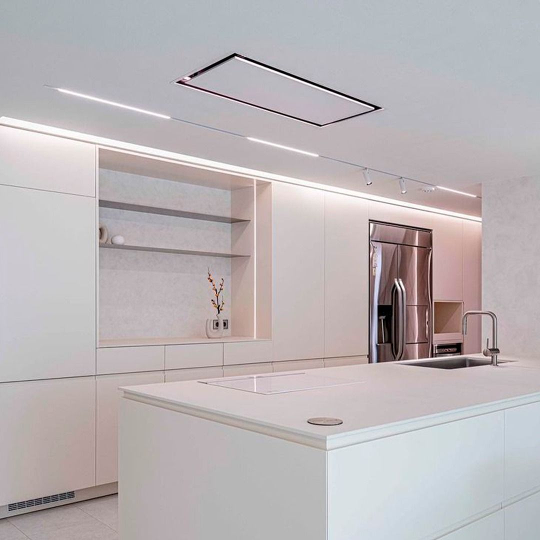 Cozinha com armários brancos, geladeira de inox, pia e ventilador de teto.