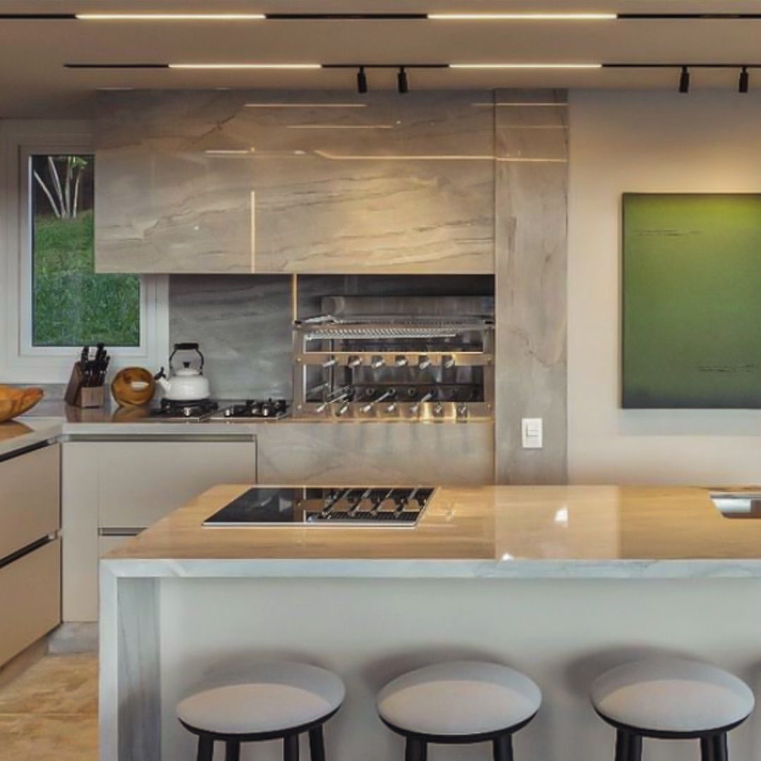 Uma cozinha com uma grande ilha e bancos