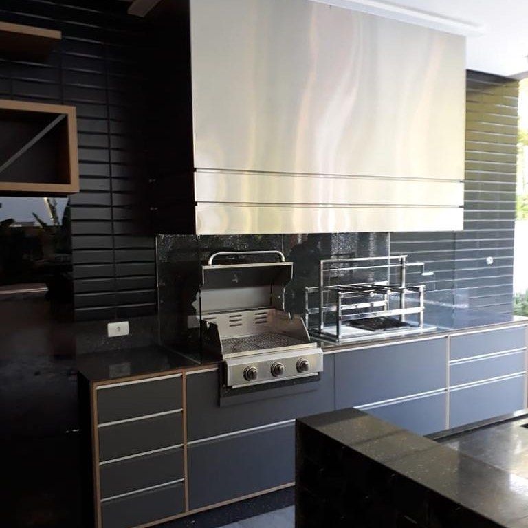 Uma cozinha com eletrodomésticos de aço inoxidável e armários pretos