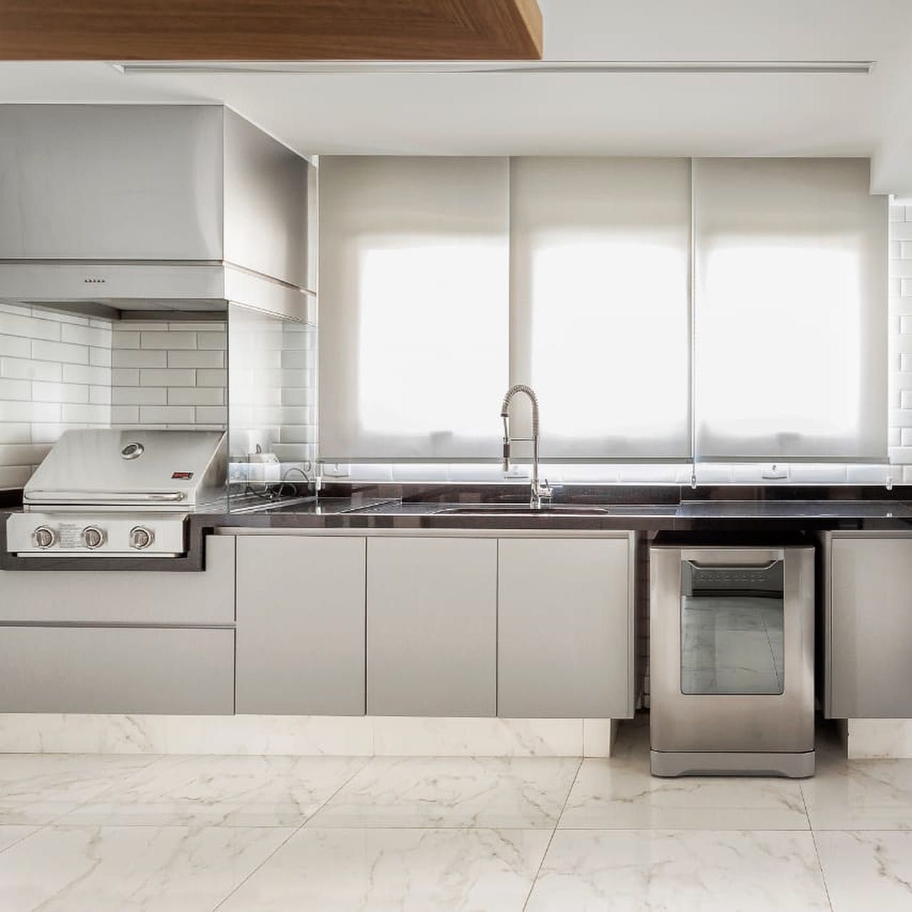 Uma cozinha com eletrodomésticos de aço inoxidável e armários brancos