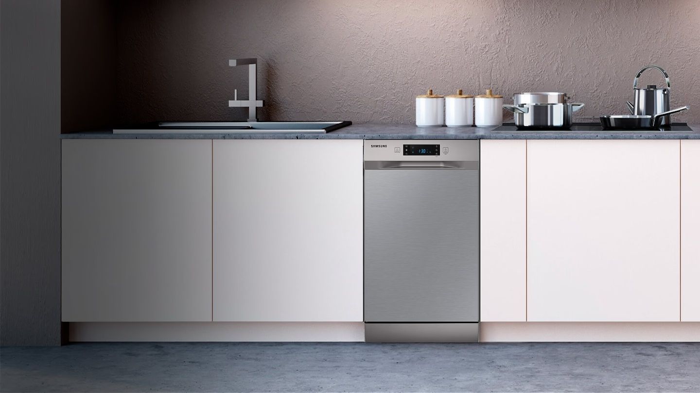 Uma cozinha com armários brancos e lava-louças em aço inoxidável.