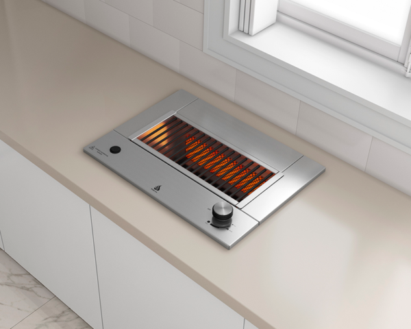 Uma grelha de aço inoxidável está em um balcão ao lado de uma janela