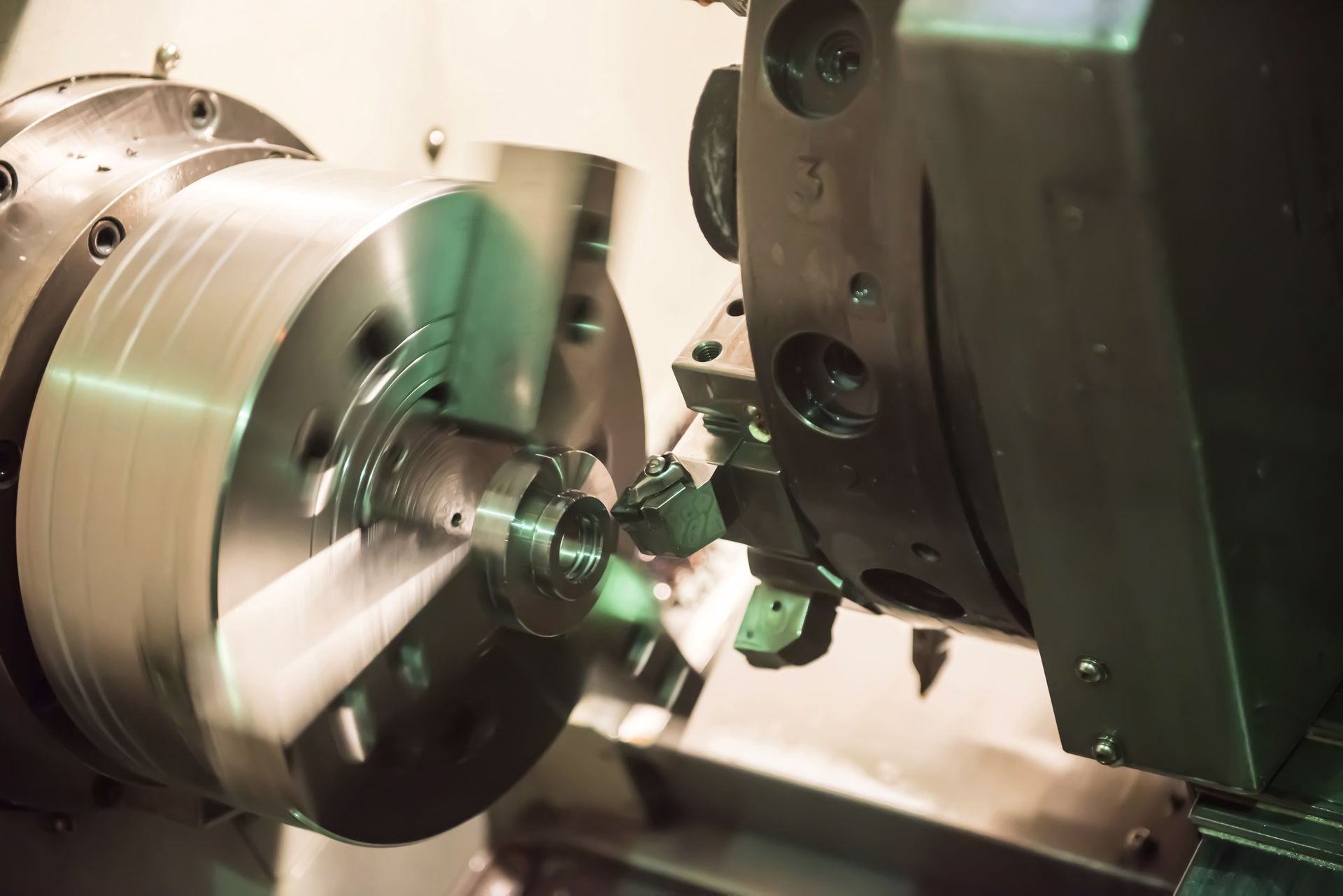 A machine is cutting a piece of metal on a lathe.