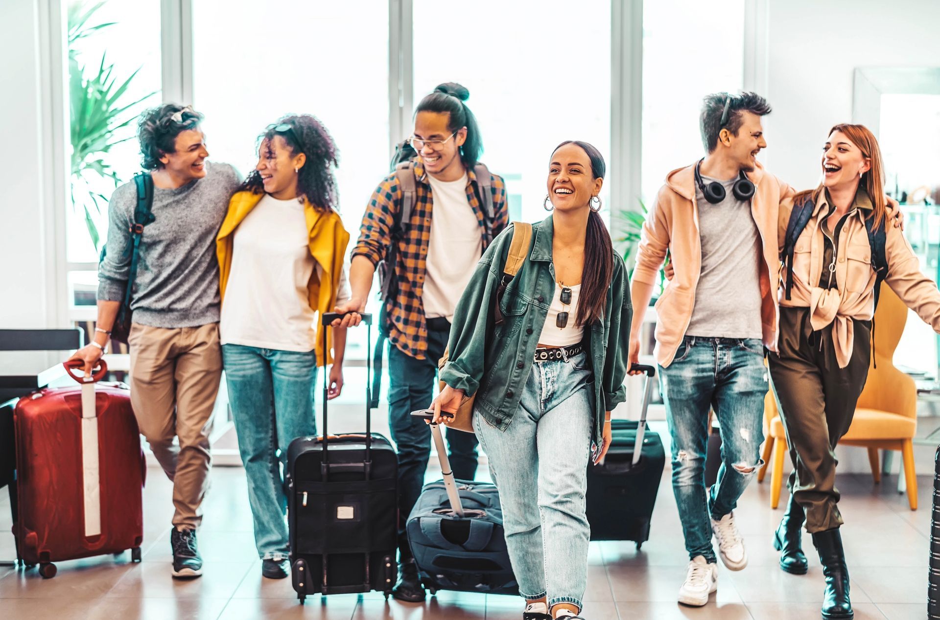 A group of people are walking through an airport with luggage.