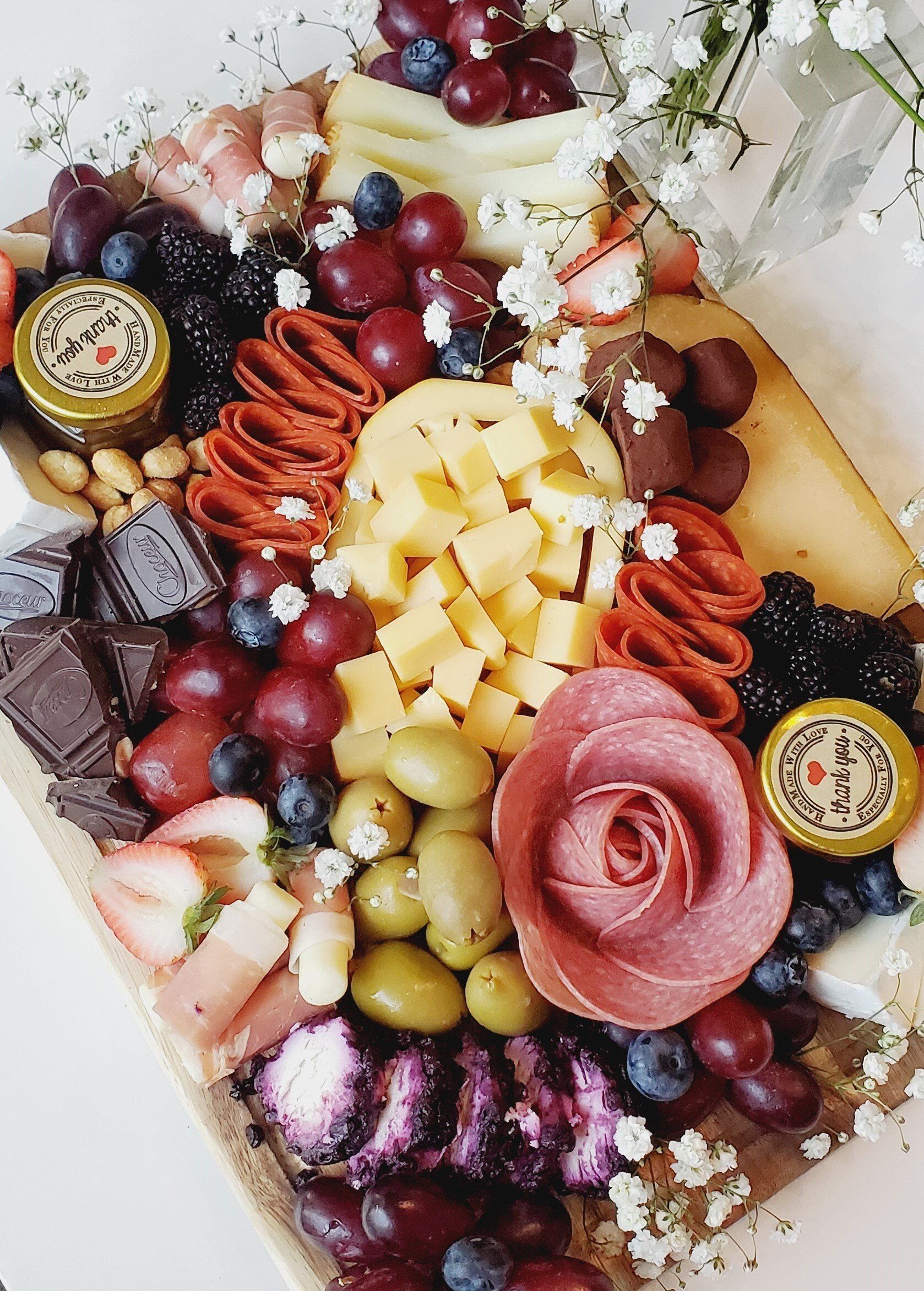A wooden cutting board filled with a variety of fruits and cheeses.