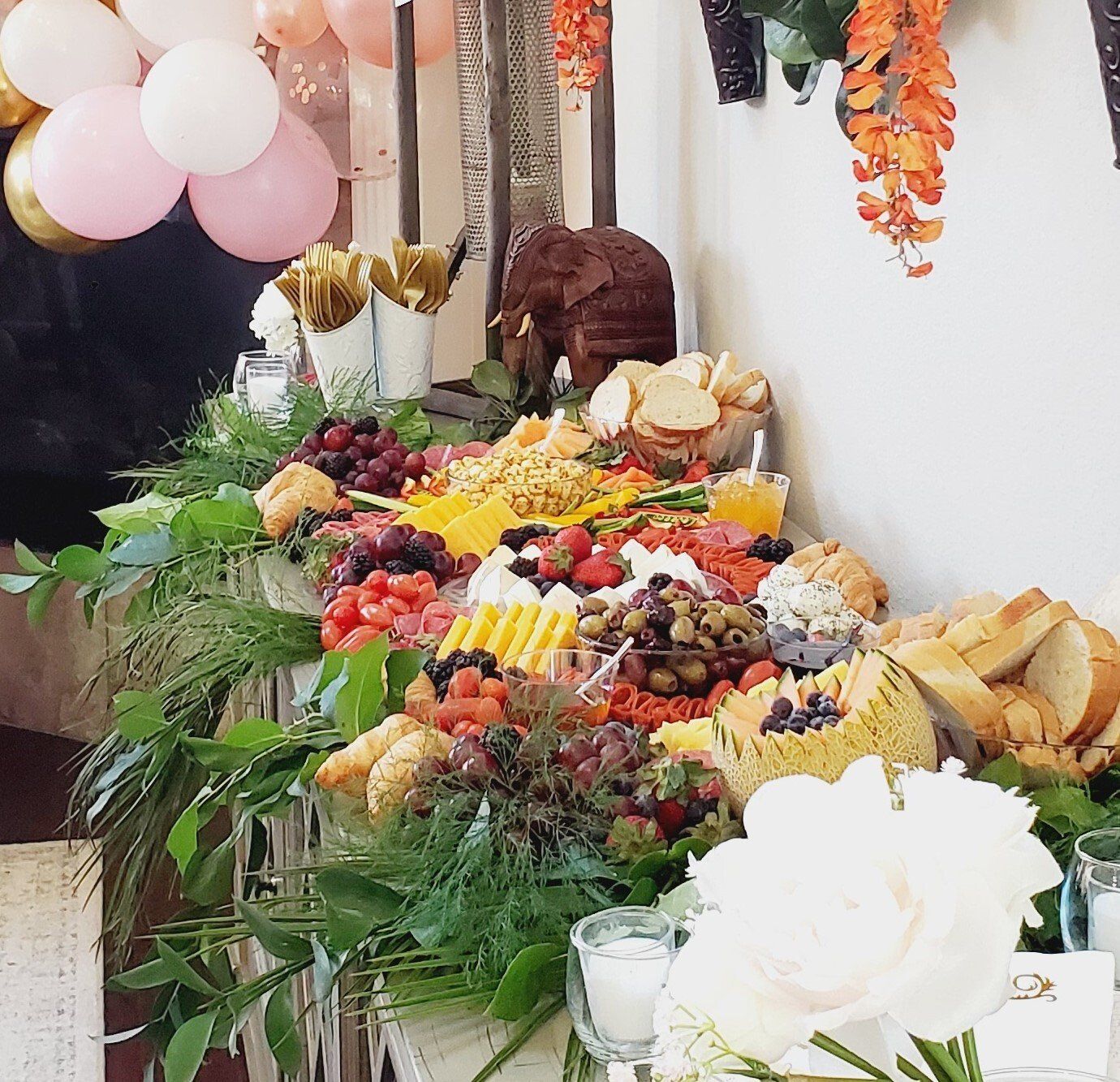 A table with lots of food and balloons on it