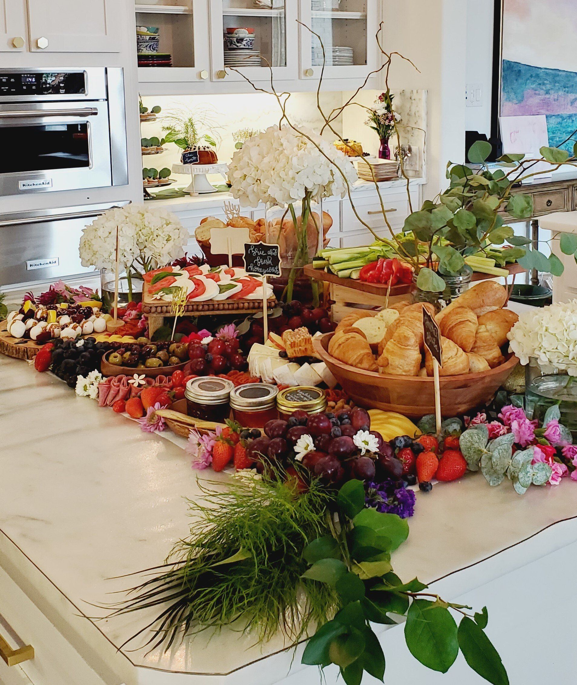 A kitchen counter filled with lots of food and flowers.
