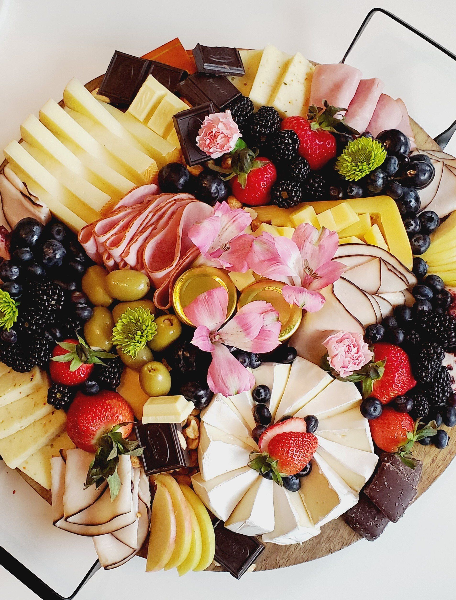 A cutting board filled with a variety of fruits and meats