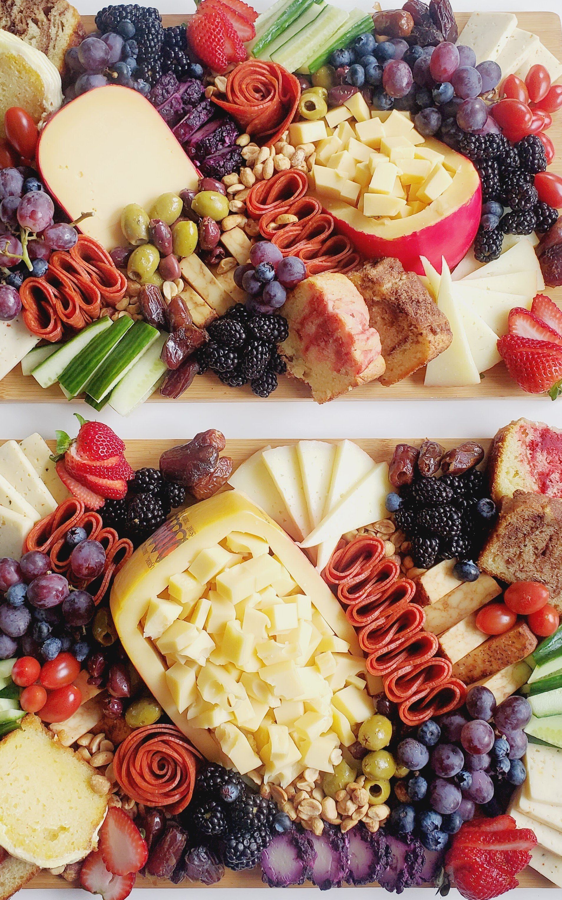 A wooden cutting board filled with cheese , fruit , vegetables , and crackers.