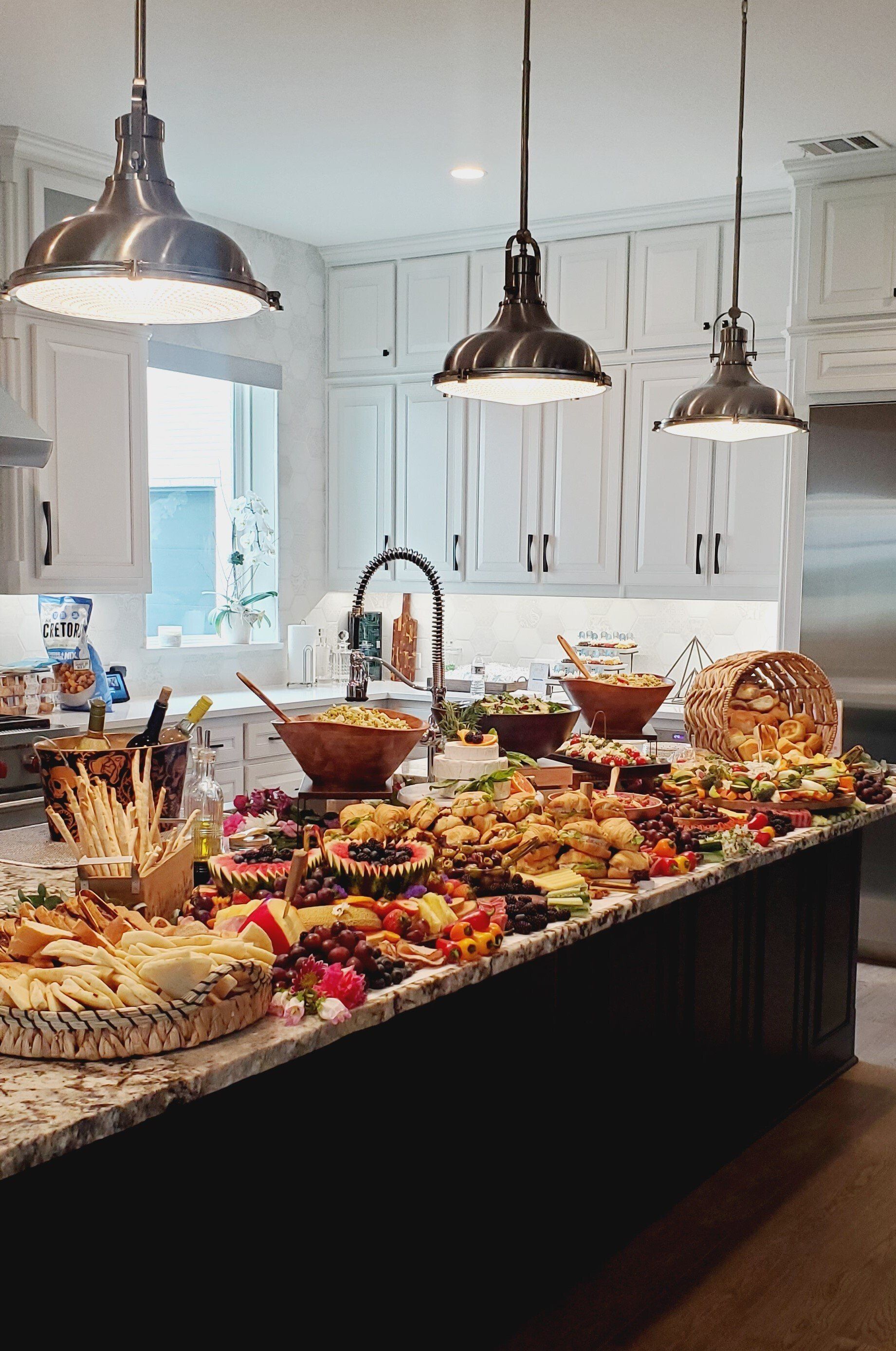 A kitchen counter filled with lots of food and plates of food.