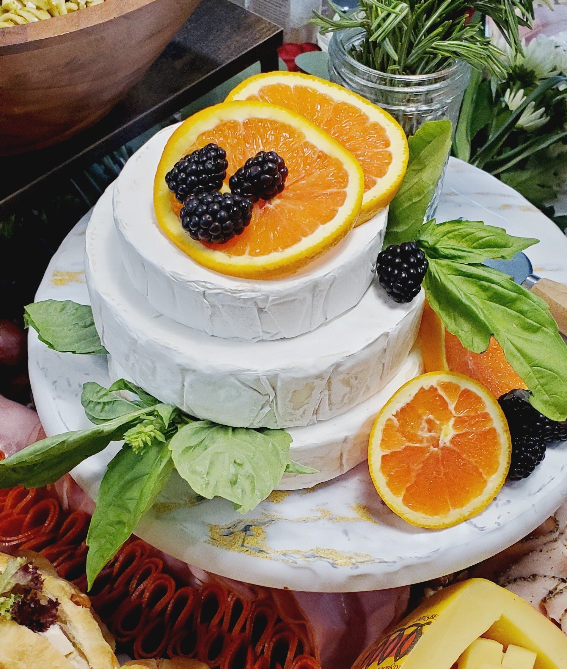 A cake with oranges and blackberries on top of it