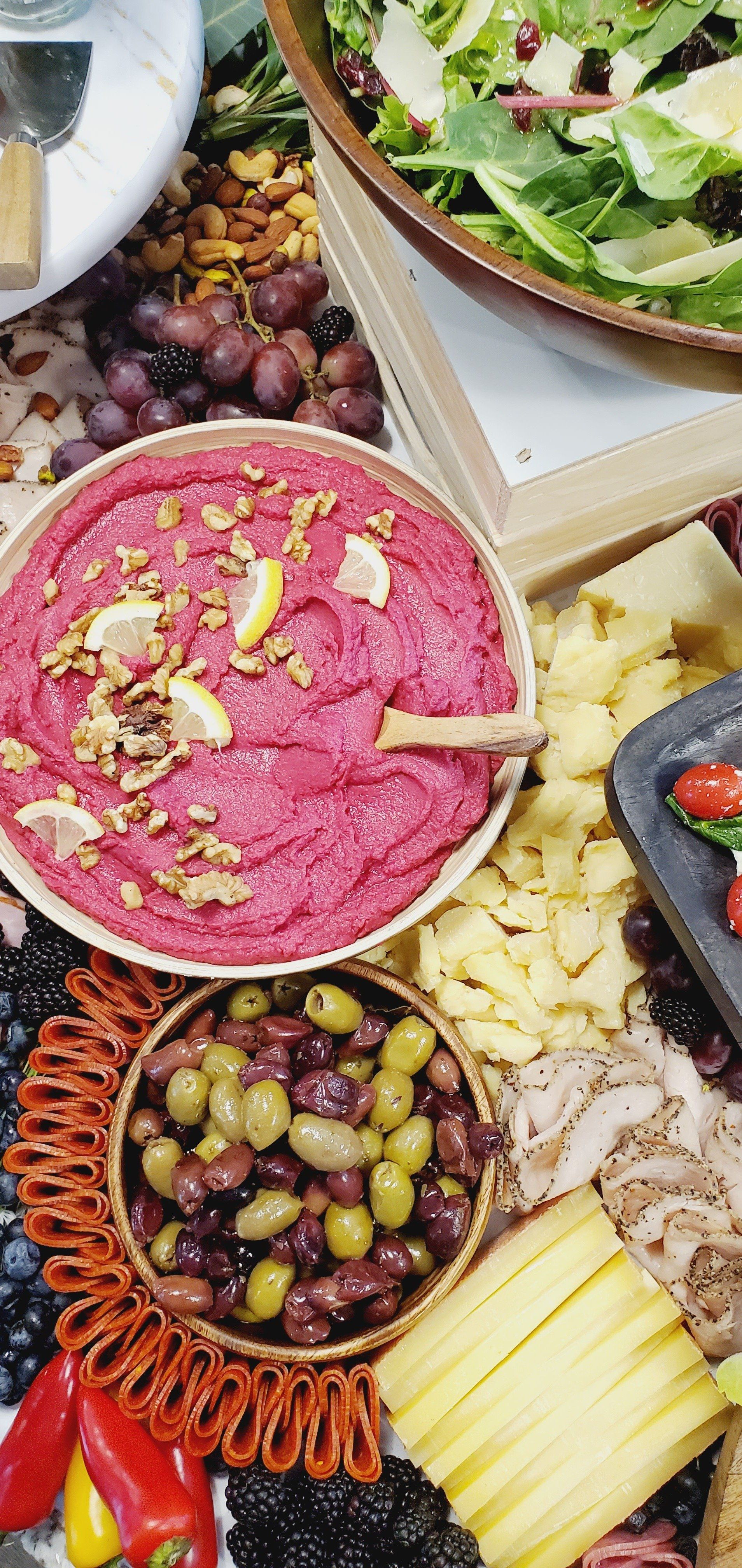 A table topped with a variety of food , including a bowl of hummus.