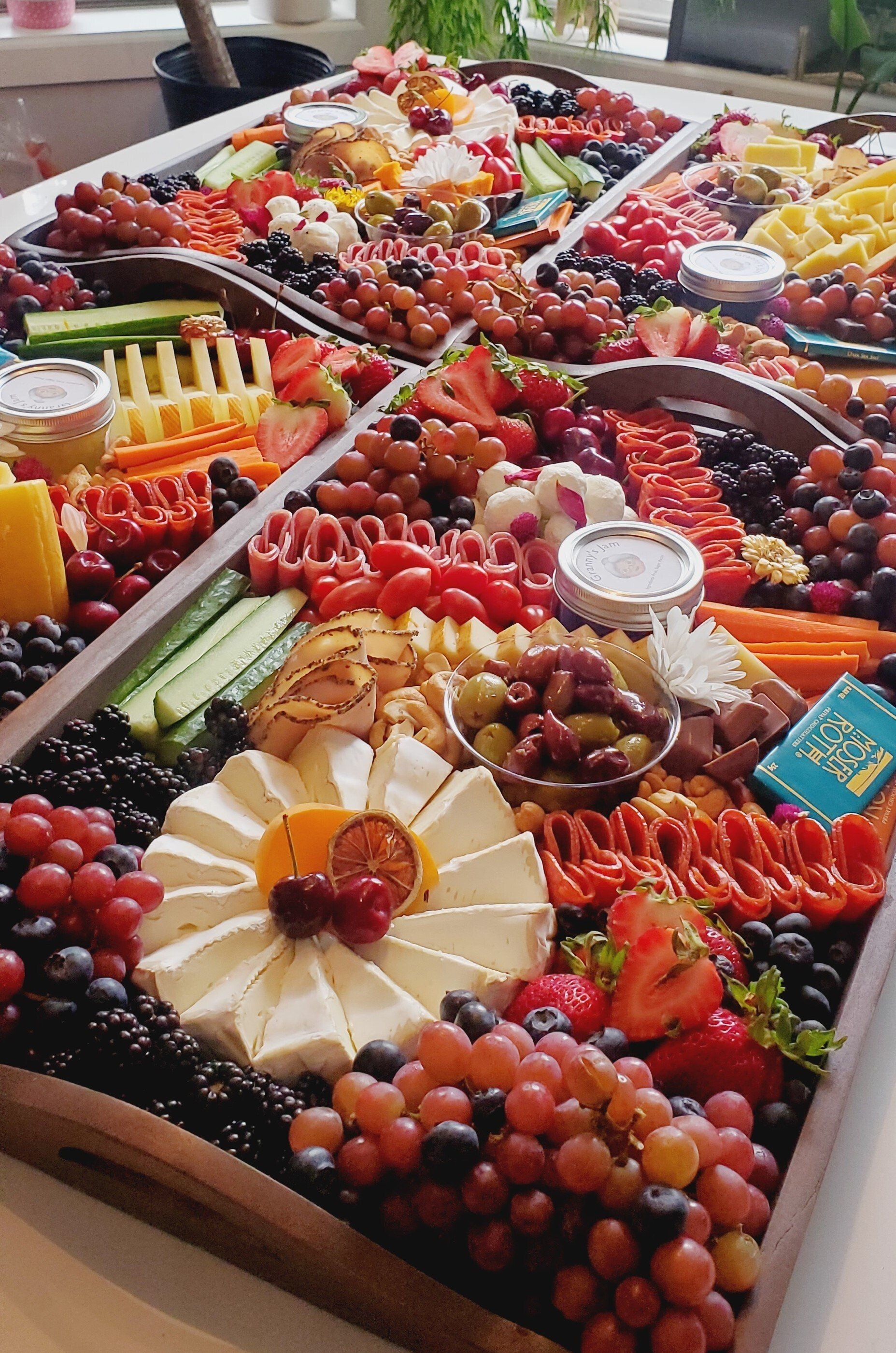 A wooden tray filled with fruits and vegetables on a table.
