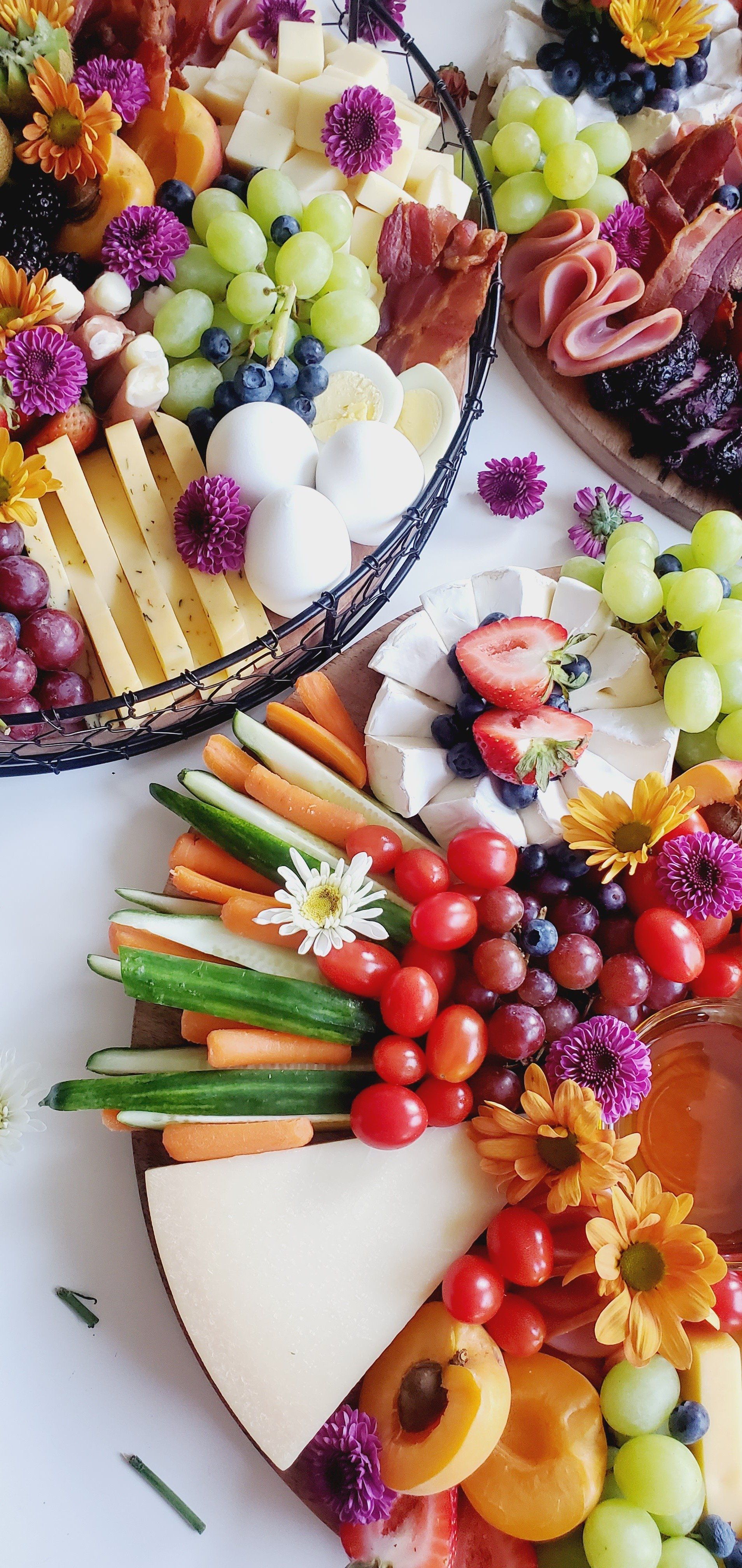 A variety of fruits and vegetables on plates on a table.