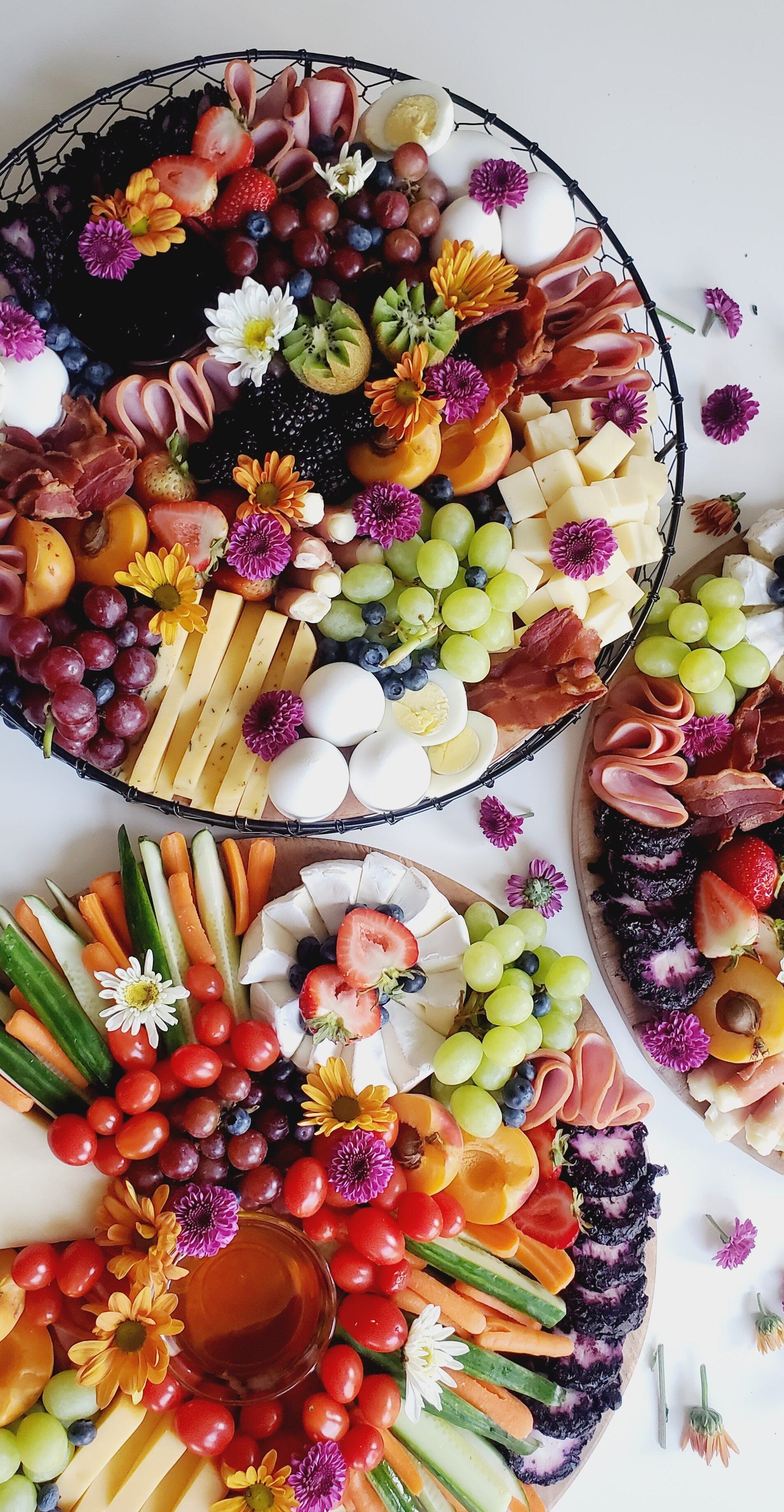 A variety of fruits and vegetables on a cutting board on a table.