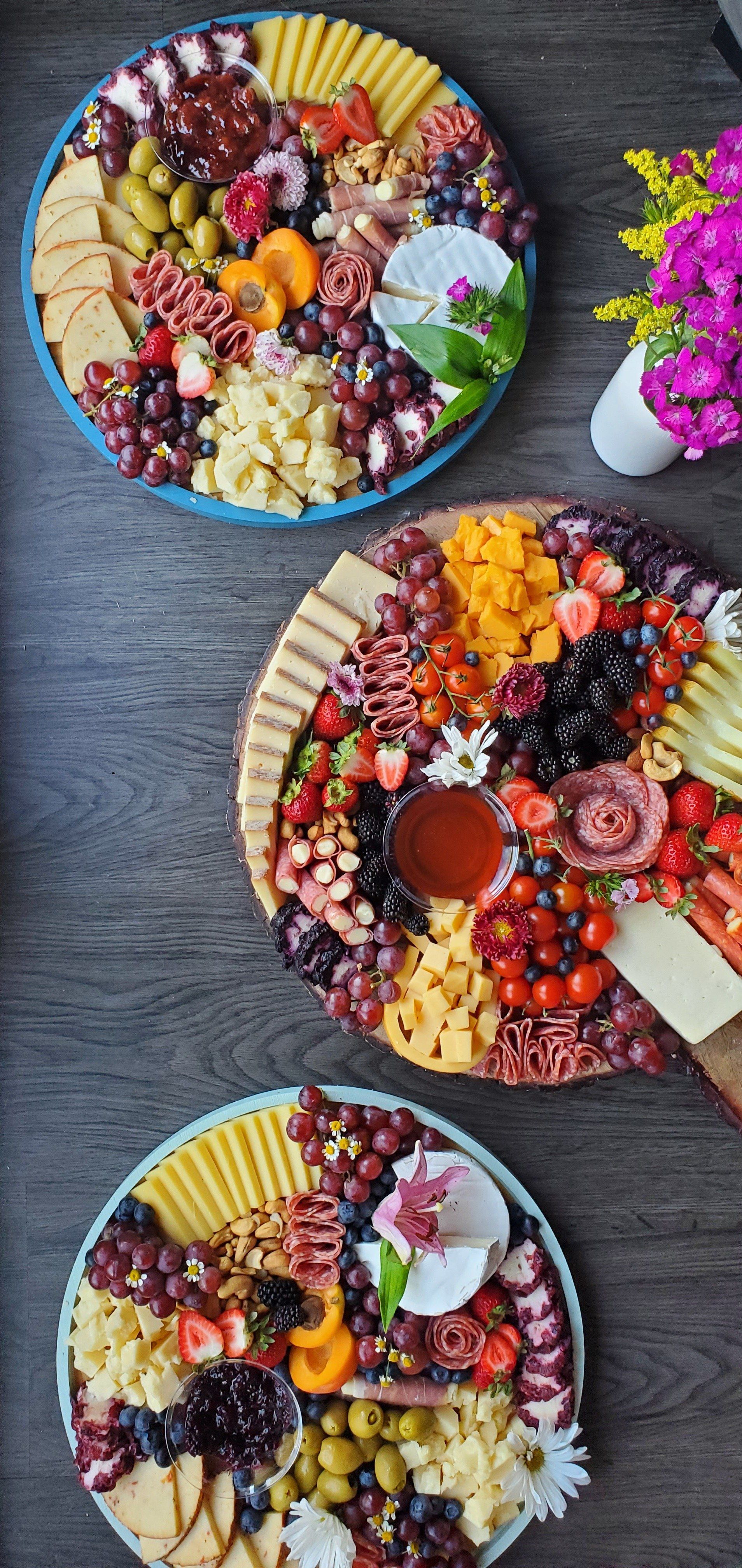 Three plates of food are sitting on a wooden table.