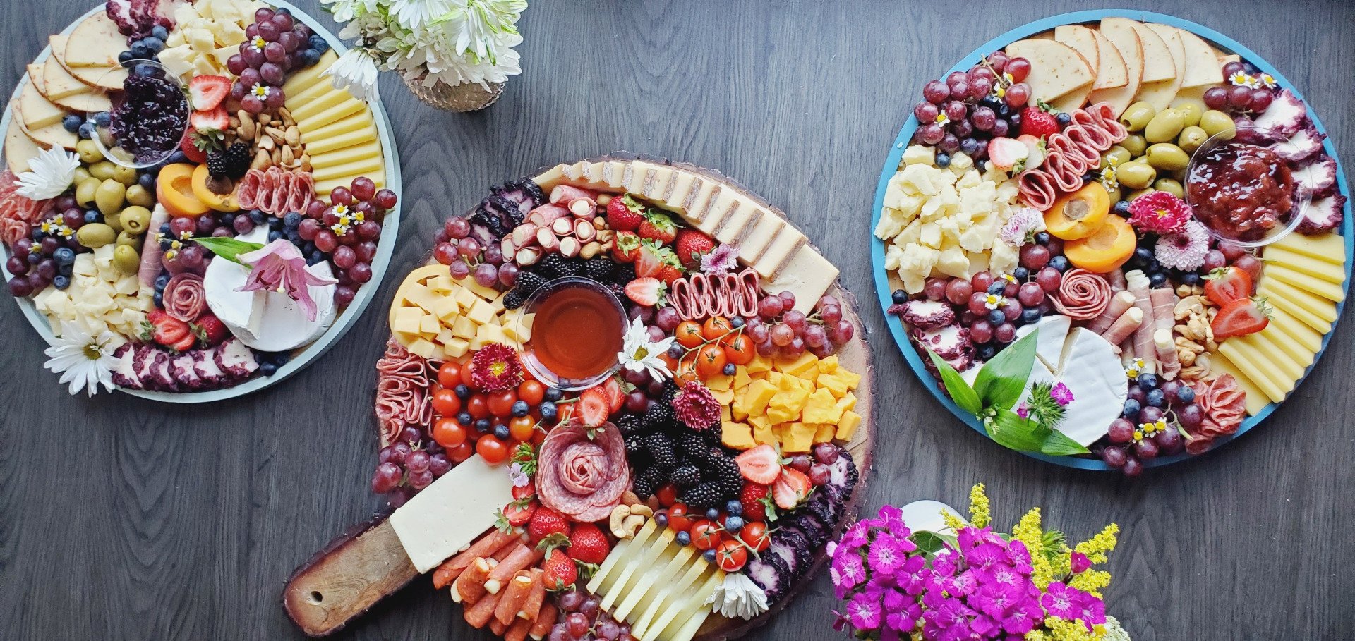 Three plates of food are sitting on a wooden table.