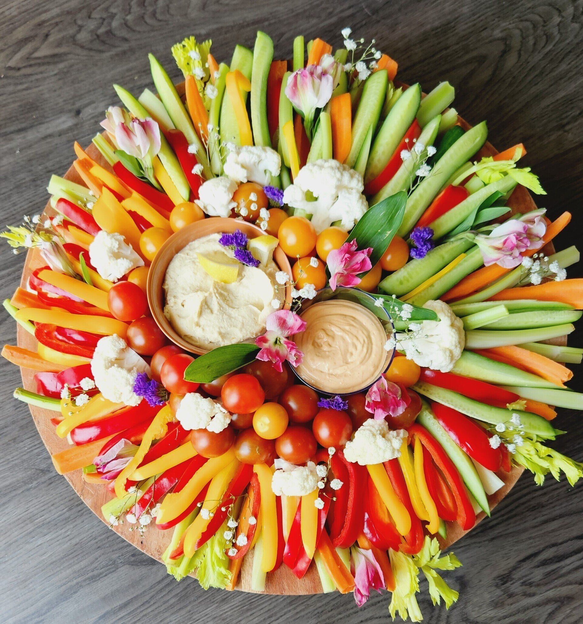 A tray of vegetables and dip on a wooden table