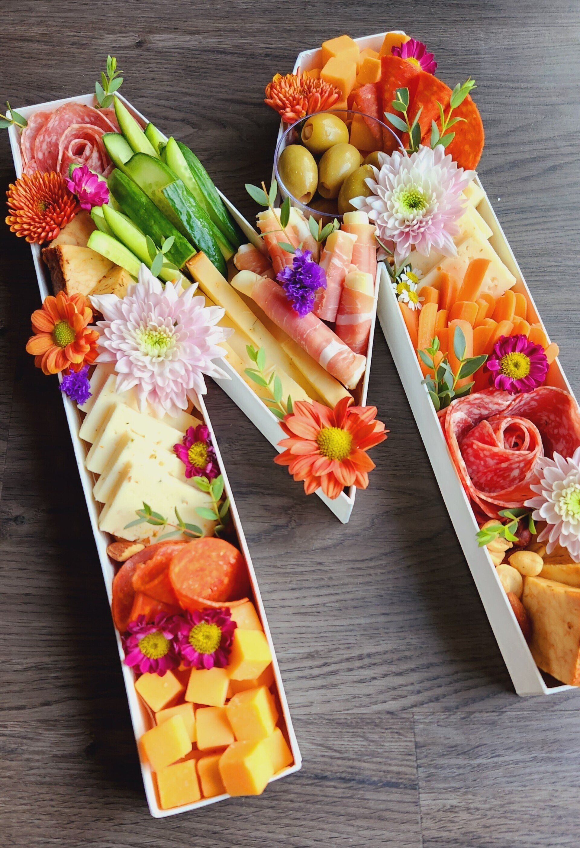 A letter m made out of food and flowers