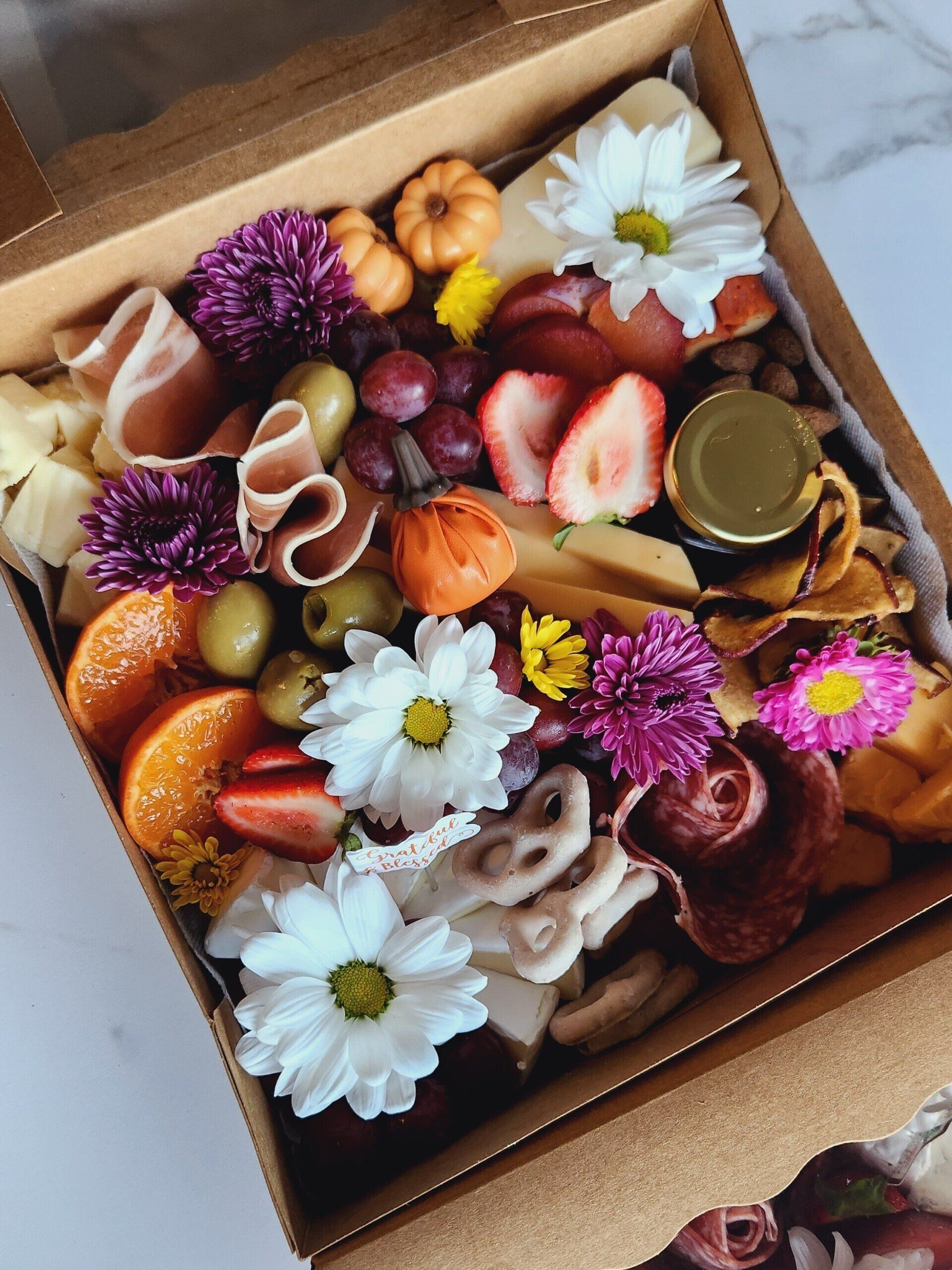 A box filled with a variety of fruits and flowers.