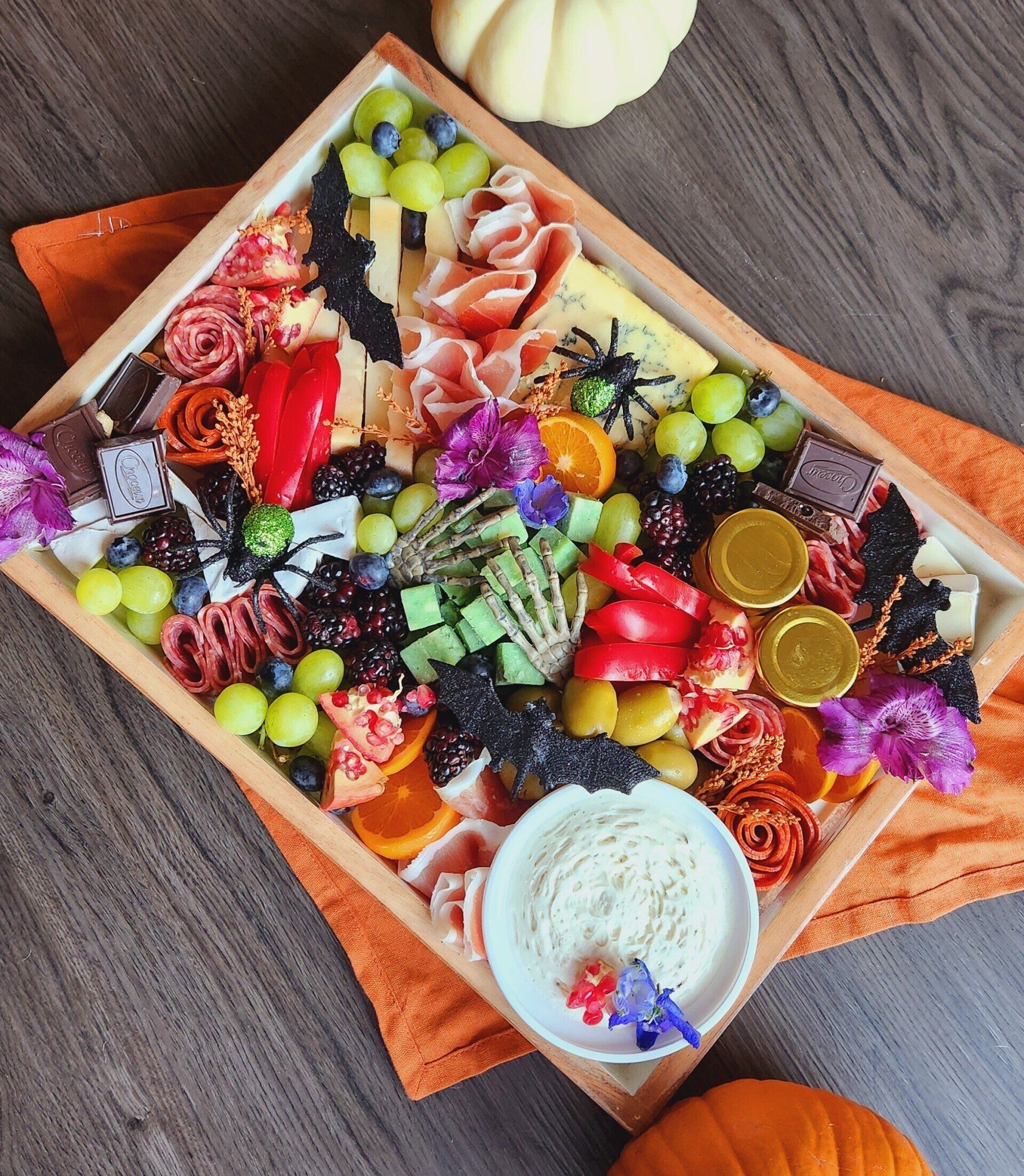 A wooden tray filled with lots of different types of food.