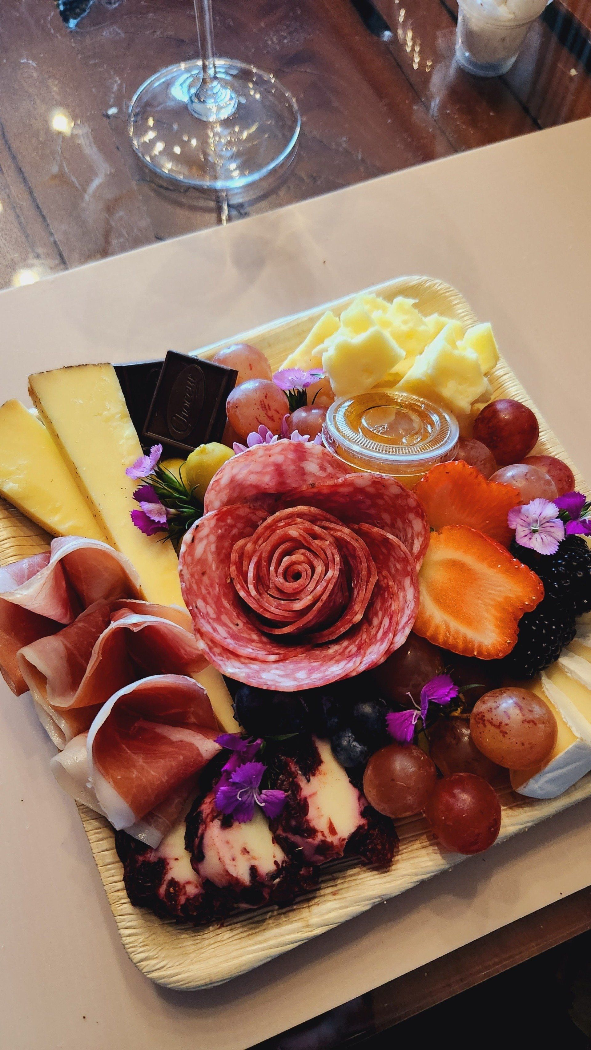 A plate of food with a rose on top of it on a table.