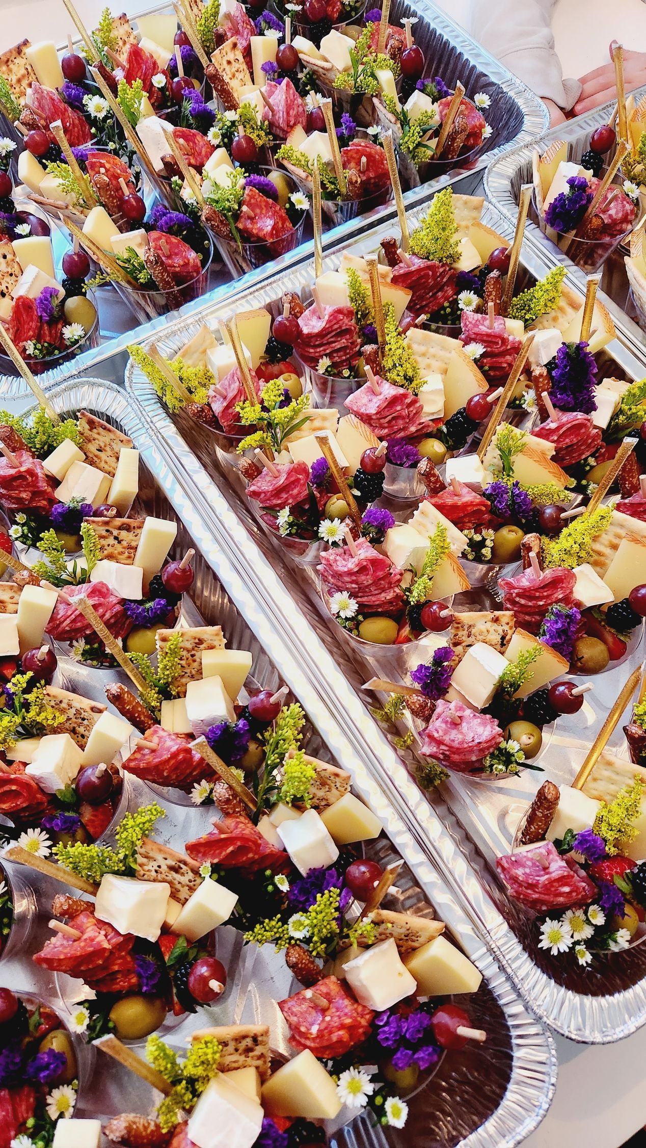 A close up of a tray of food with berries and cheese on a table.