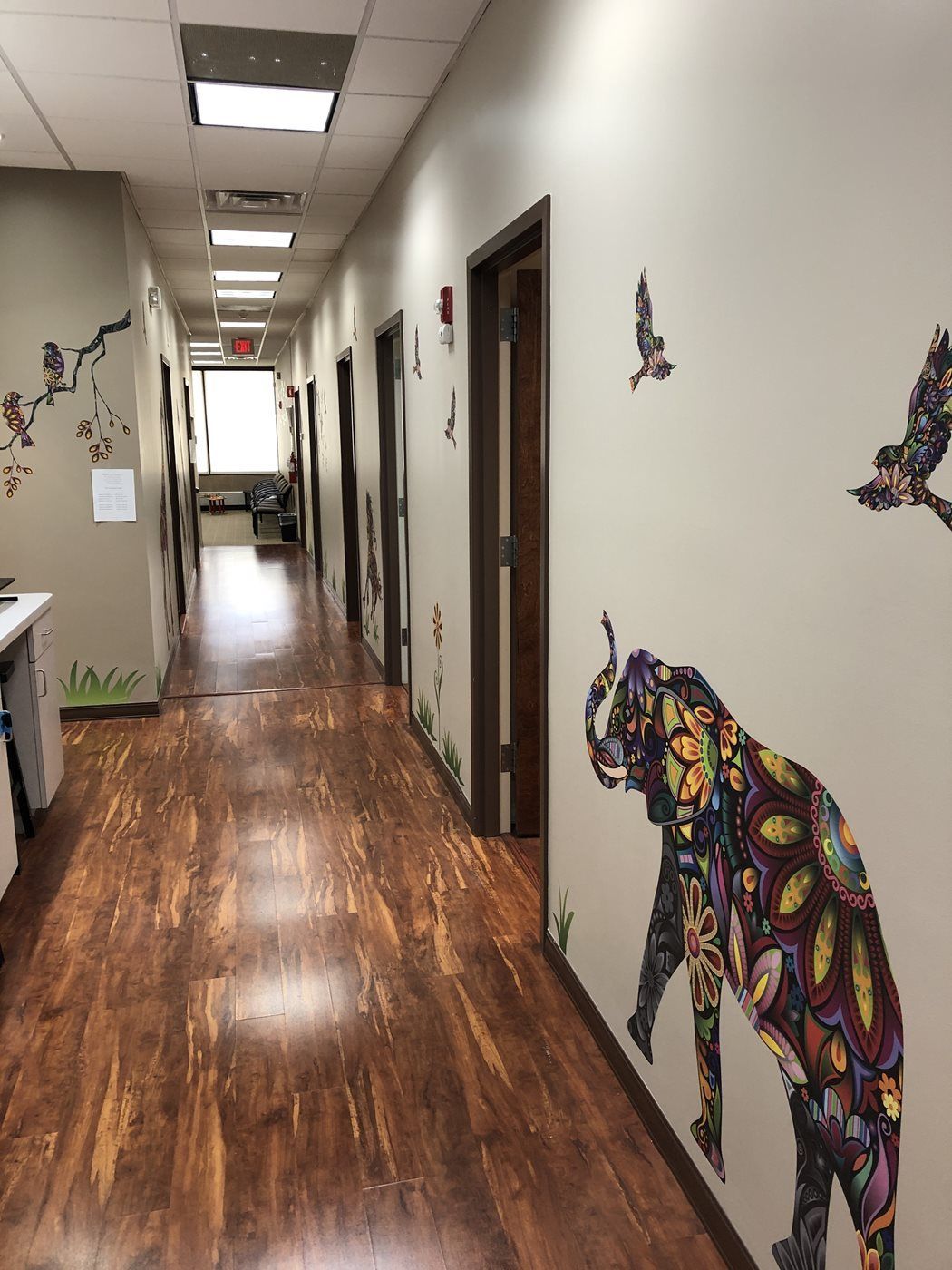 A hallway with a painting of an elephant on the wall at Advocare Washington Ave Pediatrics in Bergenfield, NJ