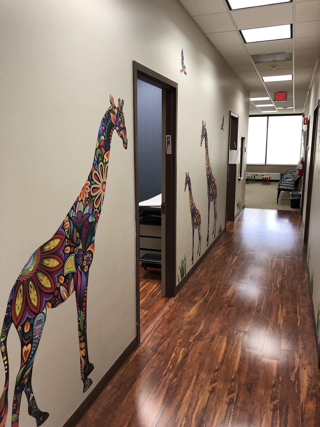 A long hallway with a giraffe on the wall at Advocare Washington Ave Pediatrics in Bergenfield, NJ