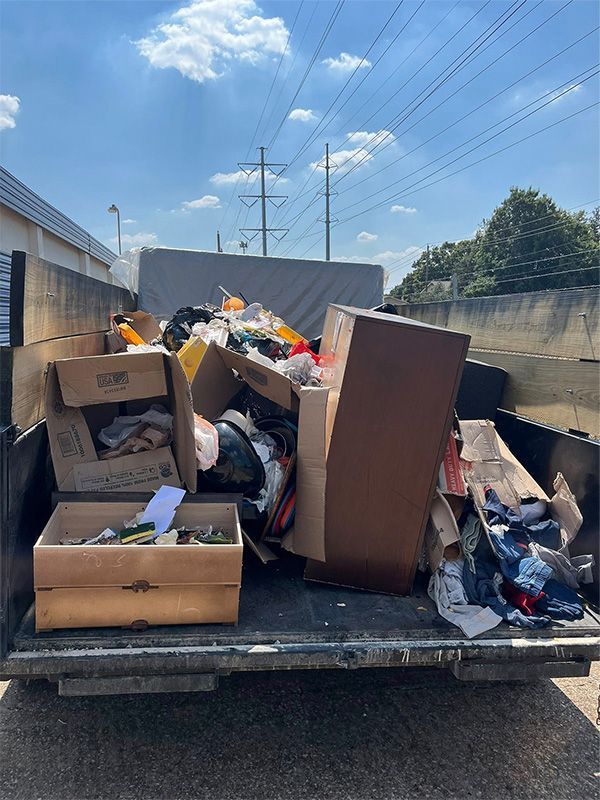 A cluttered storage space filled with various containers, some labeled with hazard symbols.
