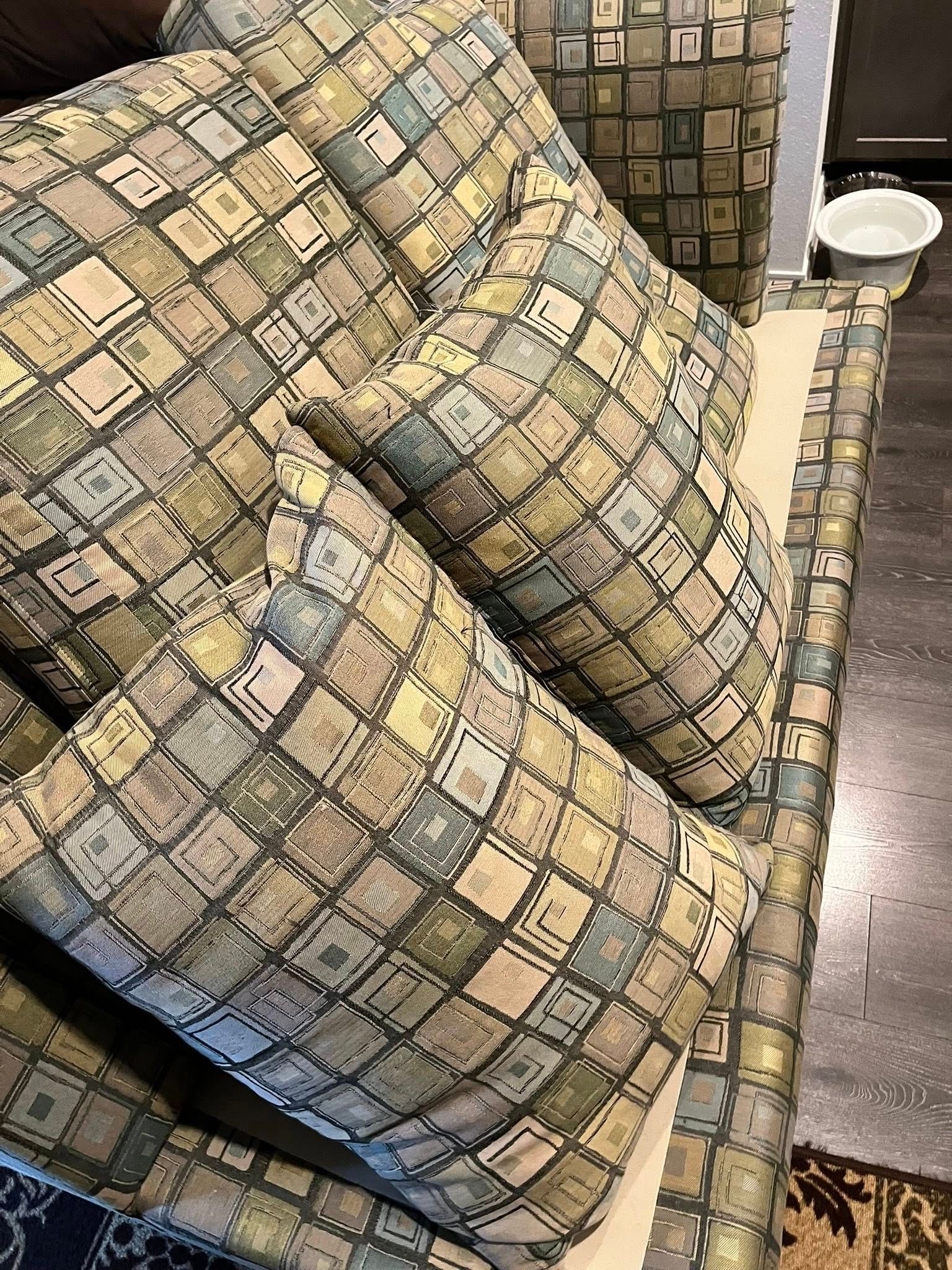 Couch with pillows, geometric print in greens, blues, and tans.