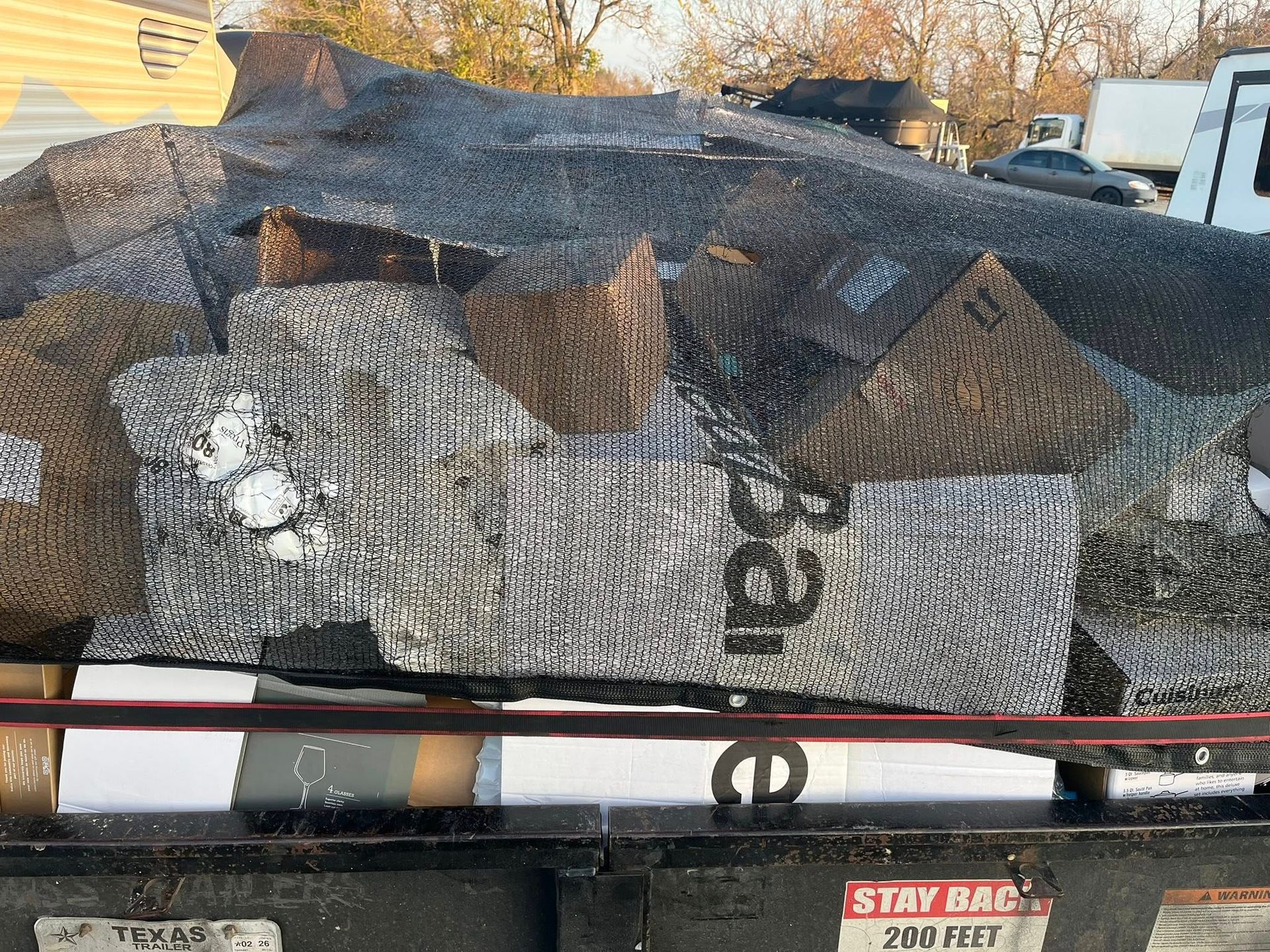 Pile of reflective insulation and cardboard boxes in a truck bed, marked 