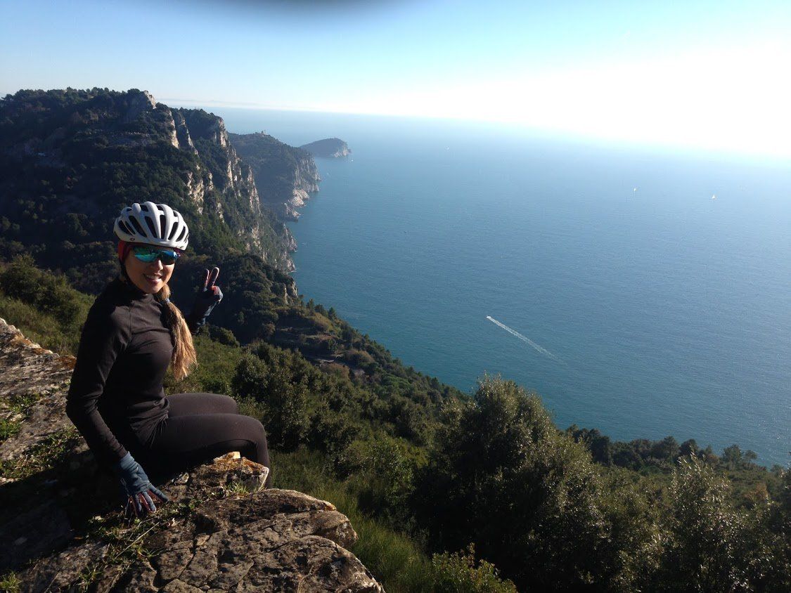 Turista in bici con panorama marino sullo sfondo