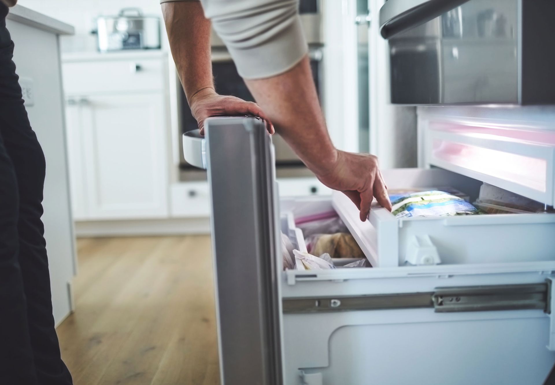 Unidentifiable Male Looking in an Opened Freezer Drawer — Geelong, VIC — Cool Cats Refrigeration