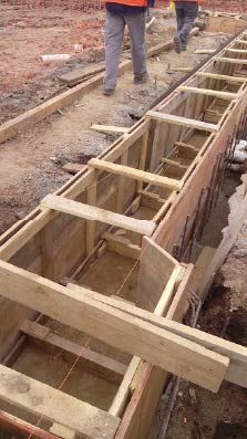 Encofrado de madera para un proyecto de construcción. Trabajadores cerca.