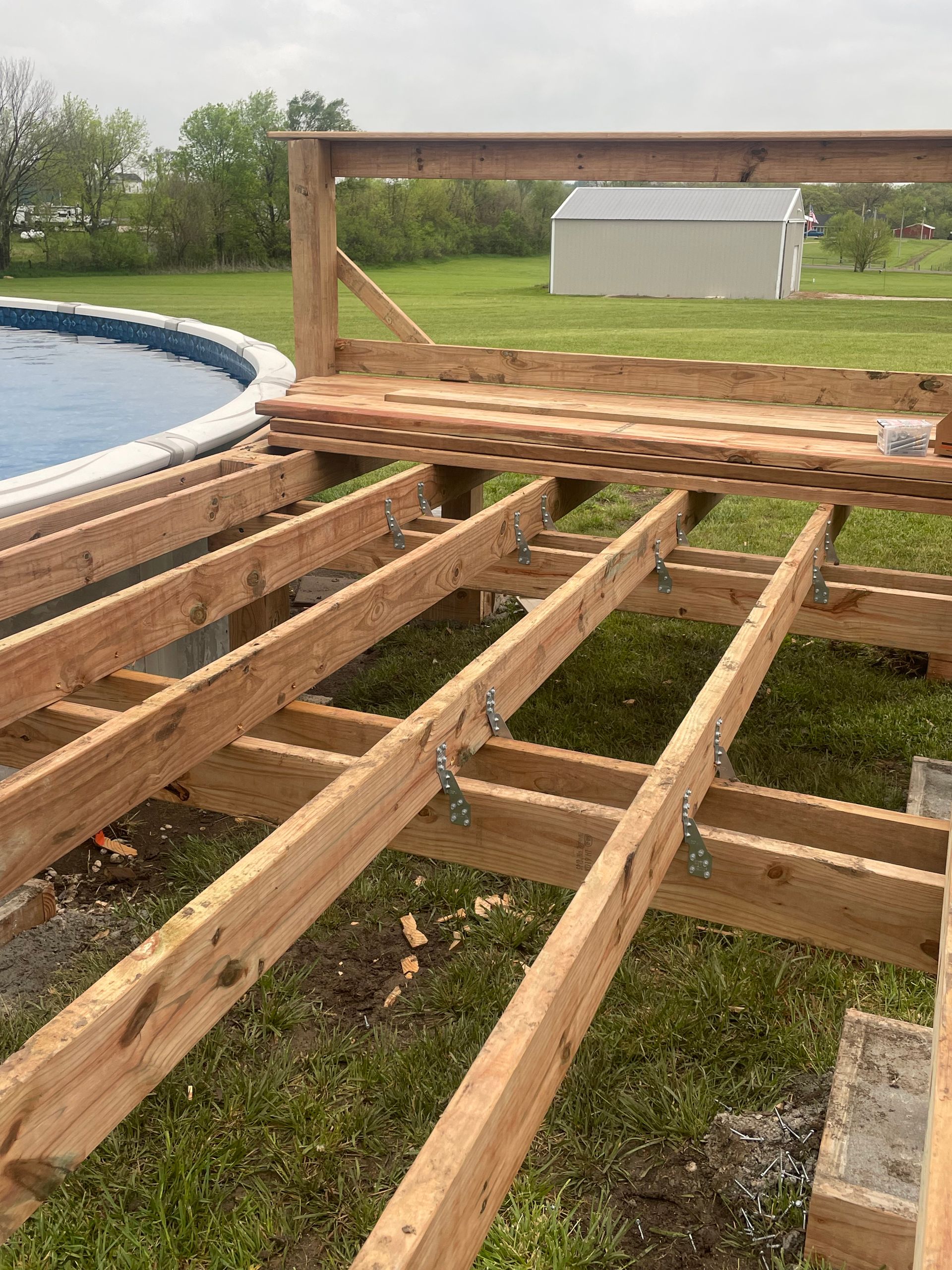 A wooden deck is being built next to a pool.
