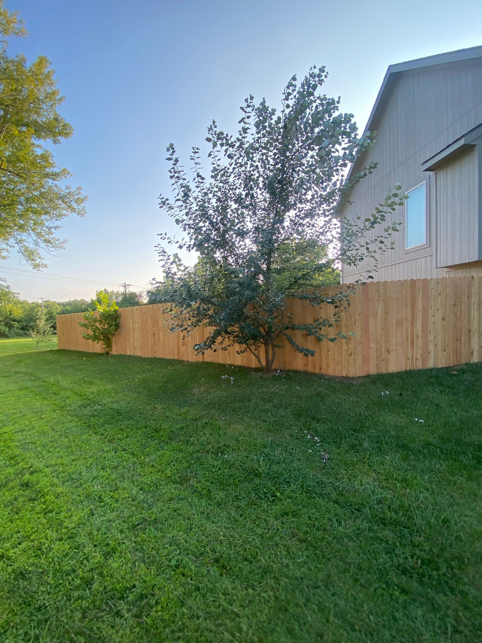 There is a wooden fence in the backyard of a house.