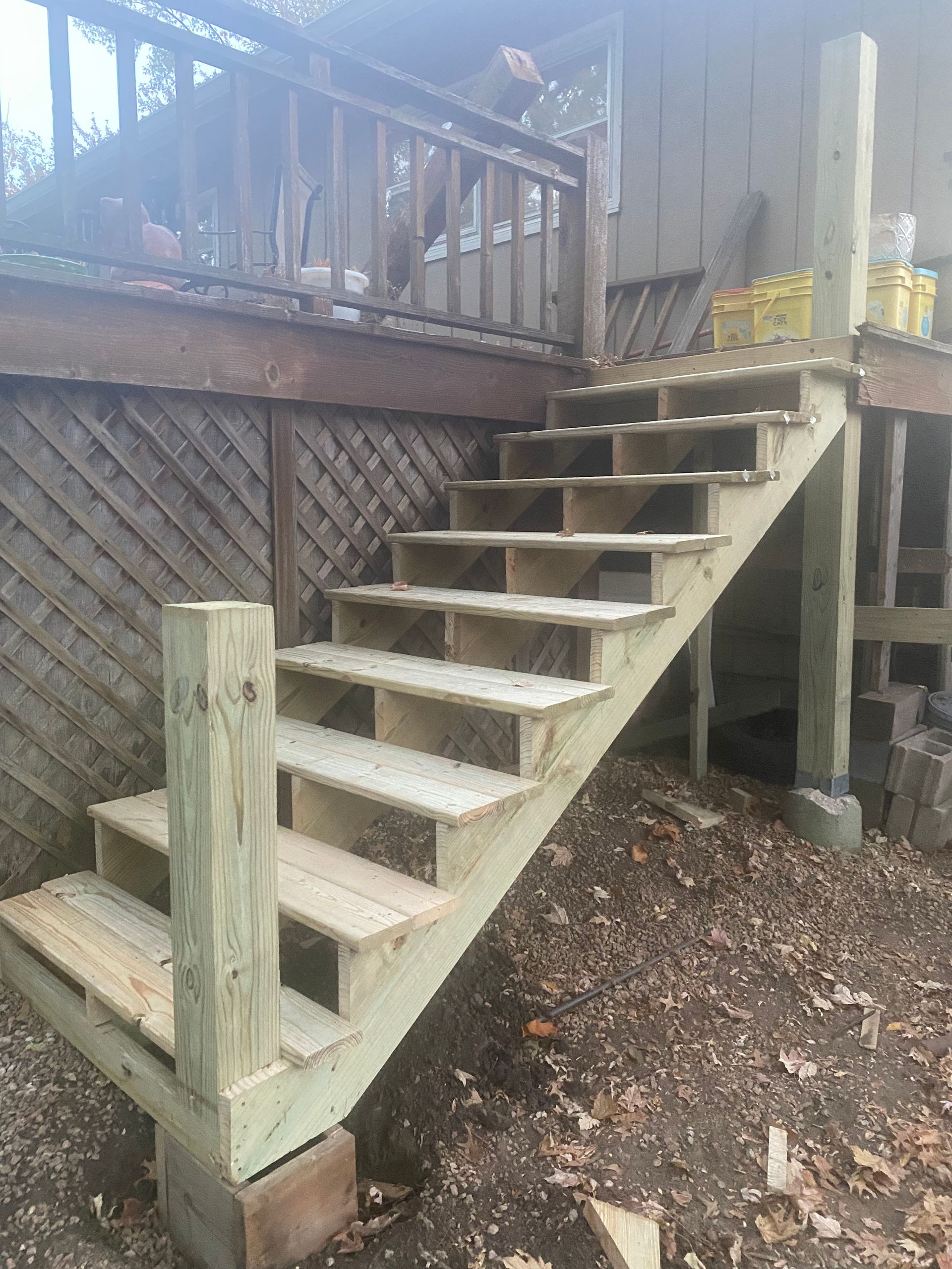 A set of wooden stairs leading up to a deck.