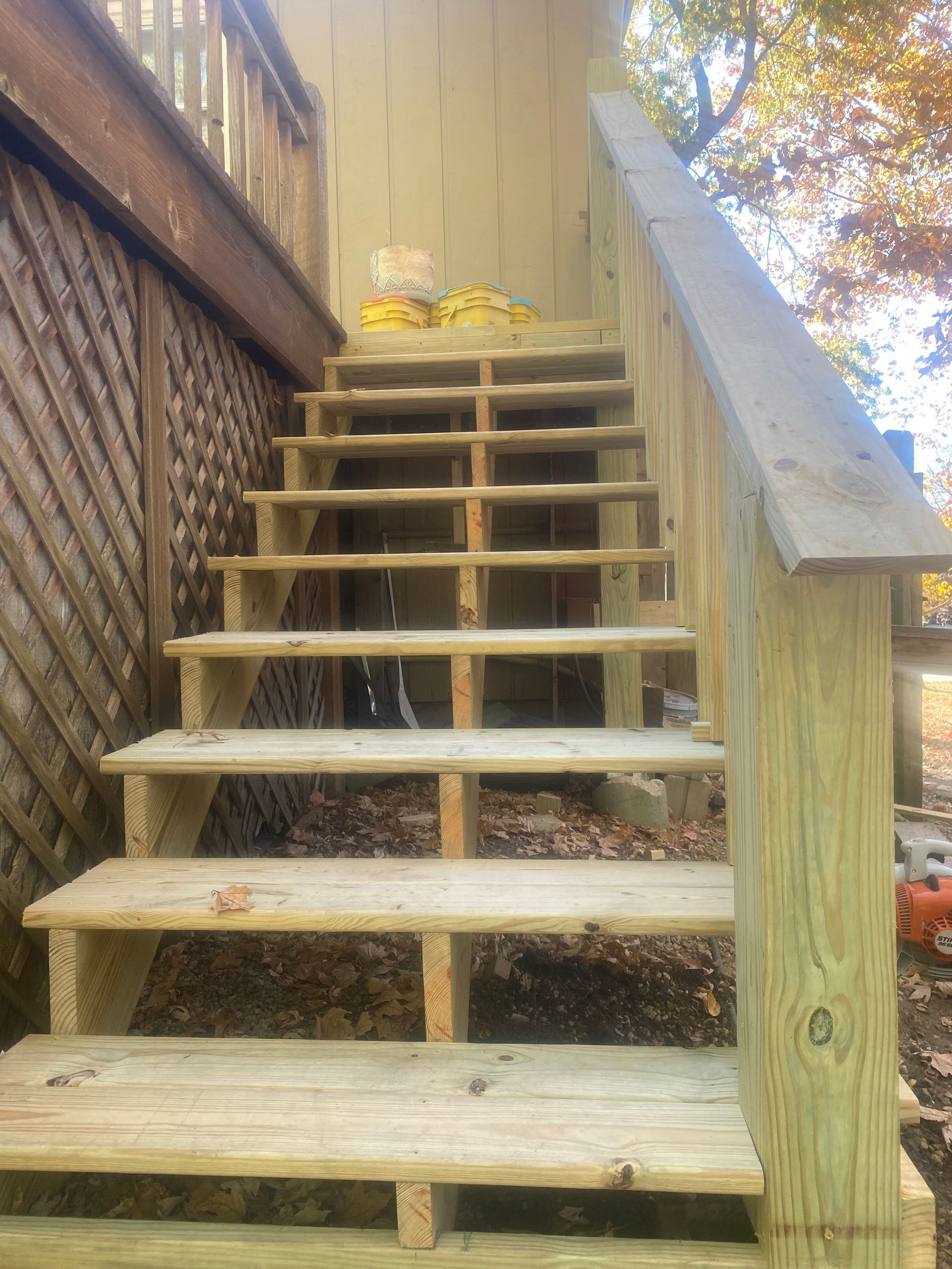 A wooden staircase is being built on the side of a house.