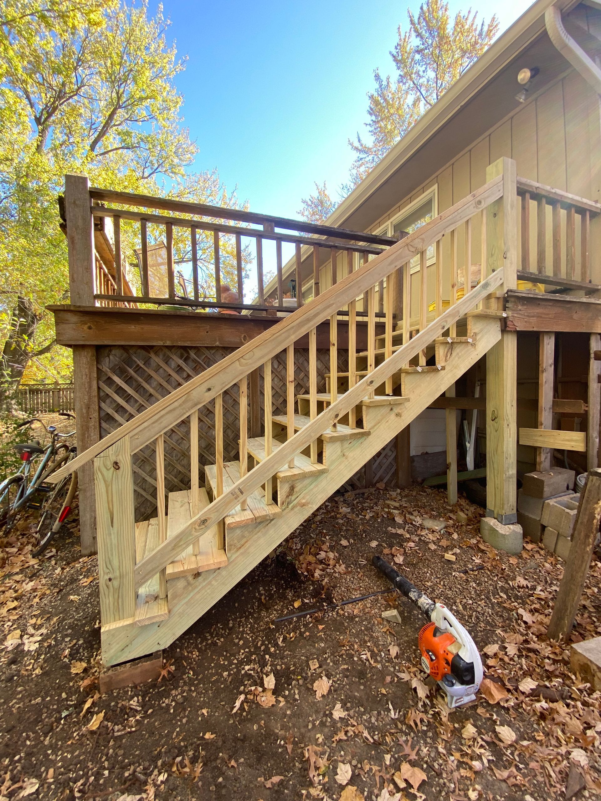 A wooden deck with stairs leading up to it is being built.