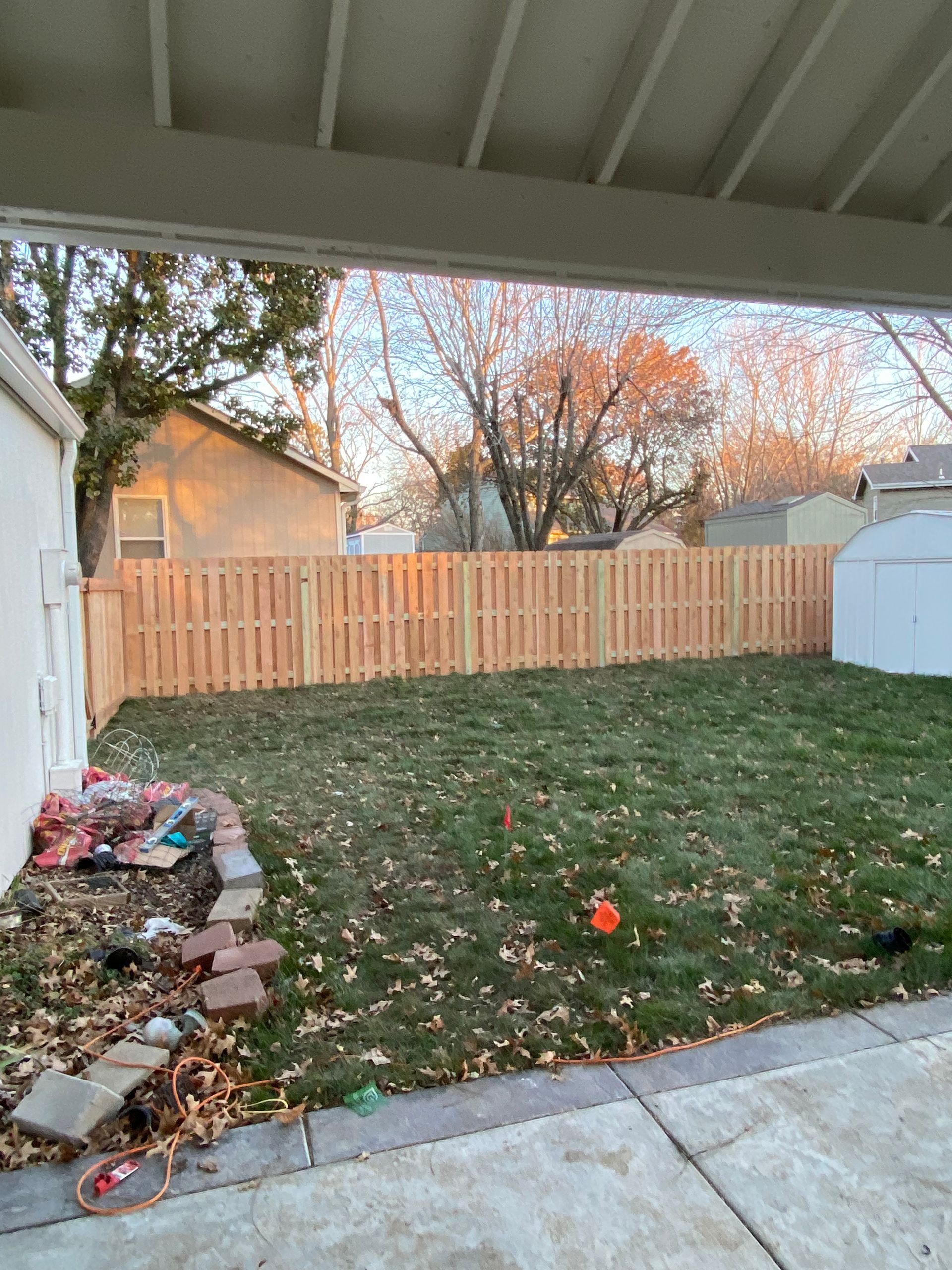 There is a wooden fence in the backyard of a house.