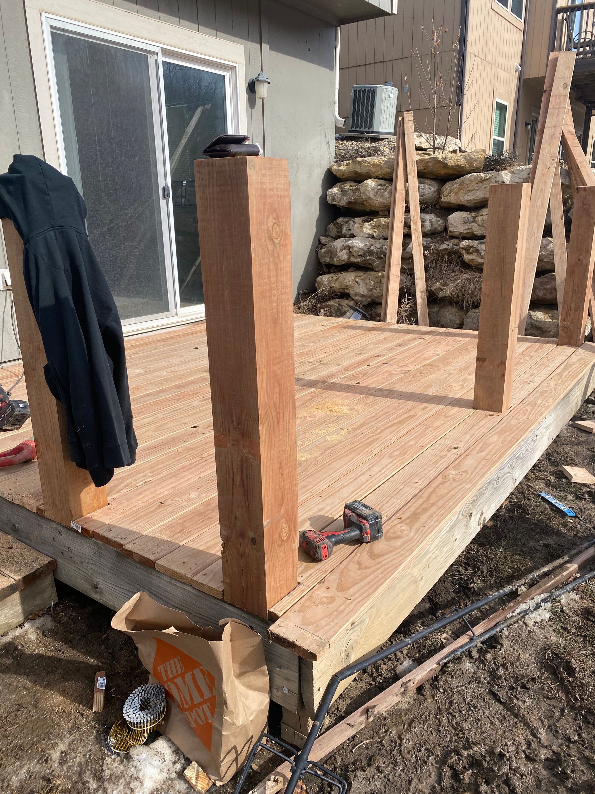 A wooden deck is being built in front of a house.