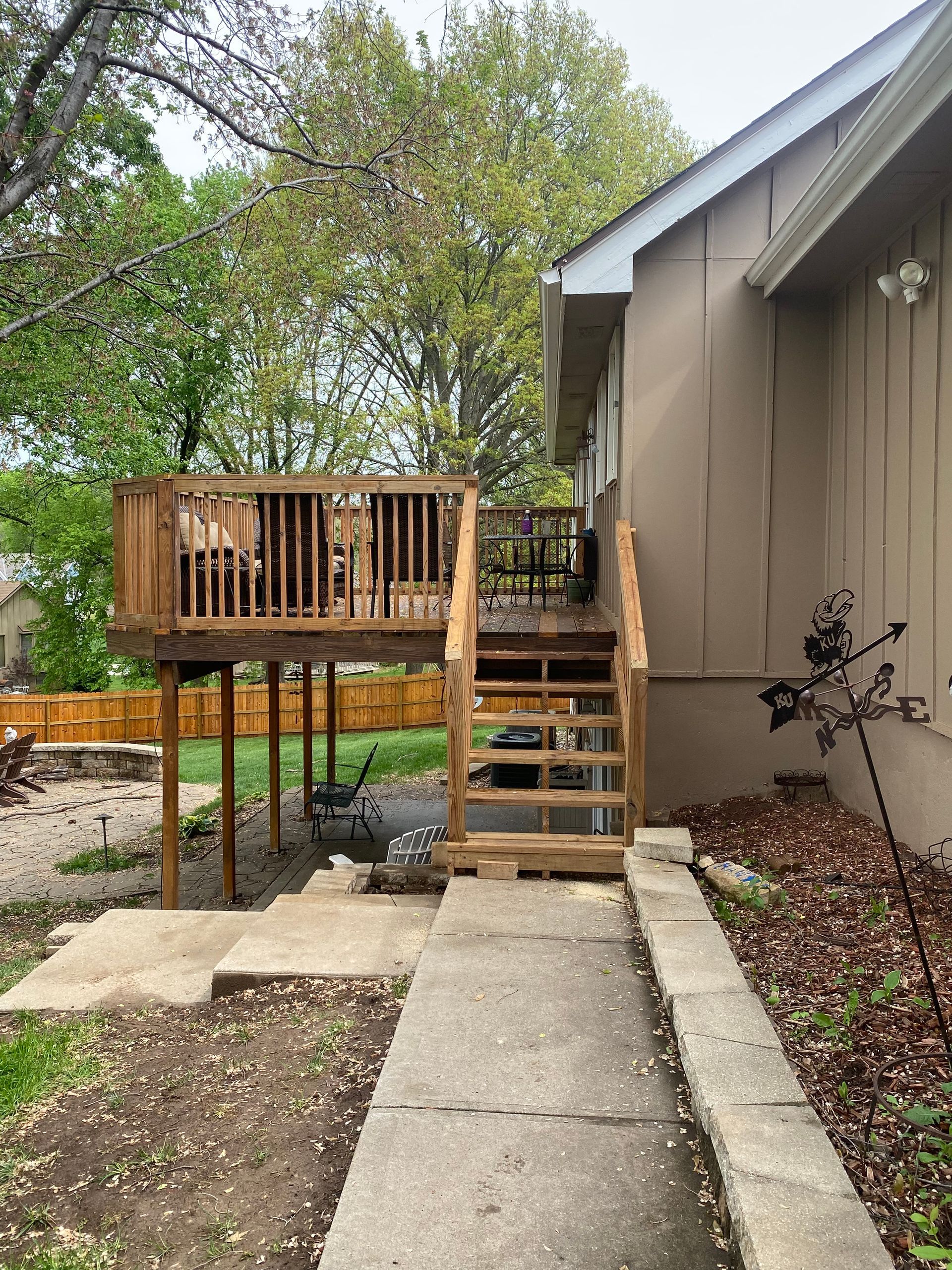 A house with a wooden deck and stairs leading to it.