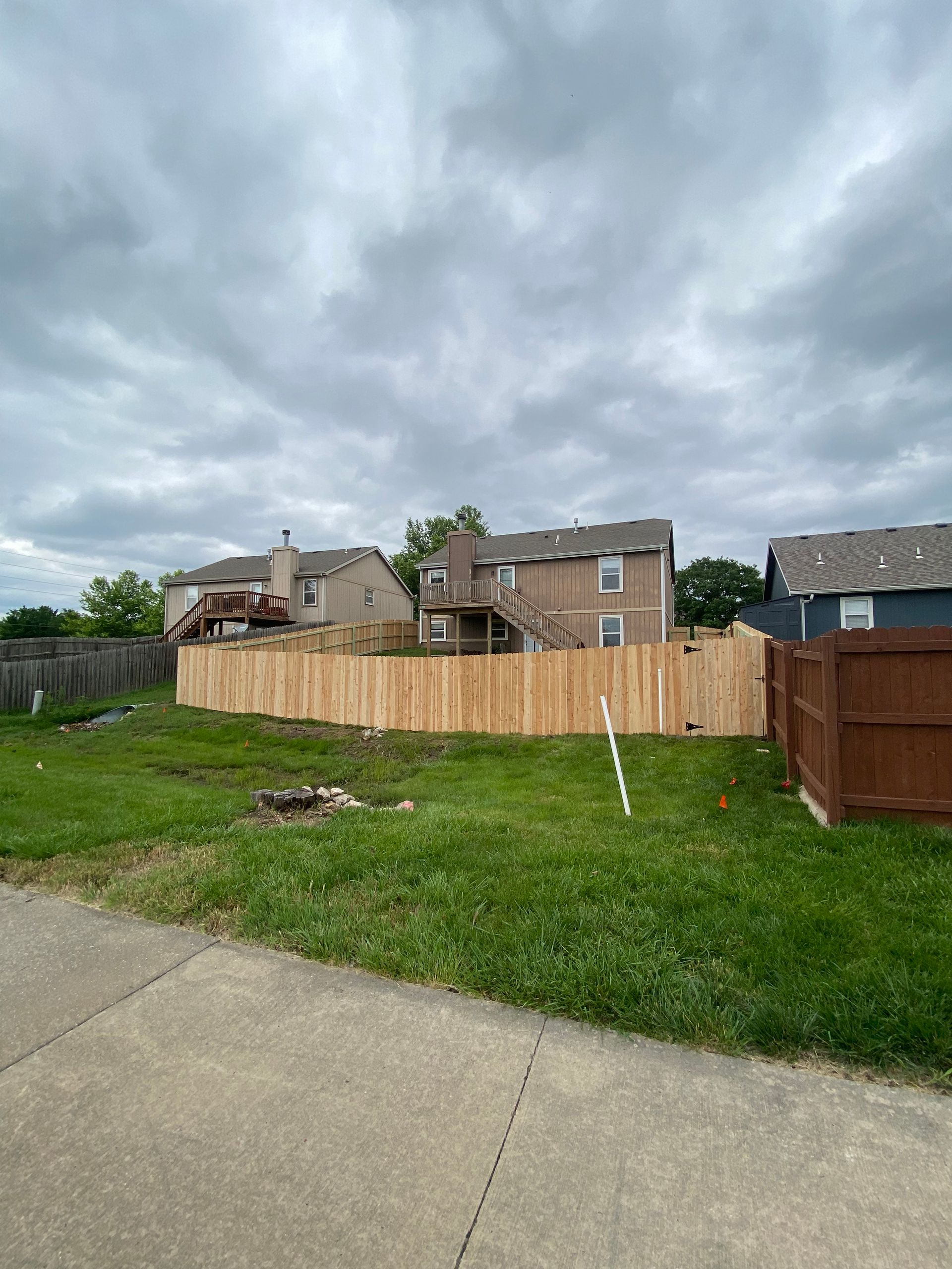 There is a wooden fence in the middle of a grassy field.