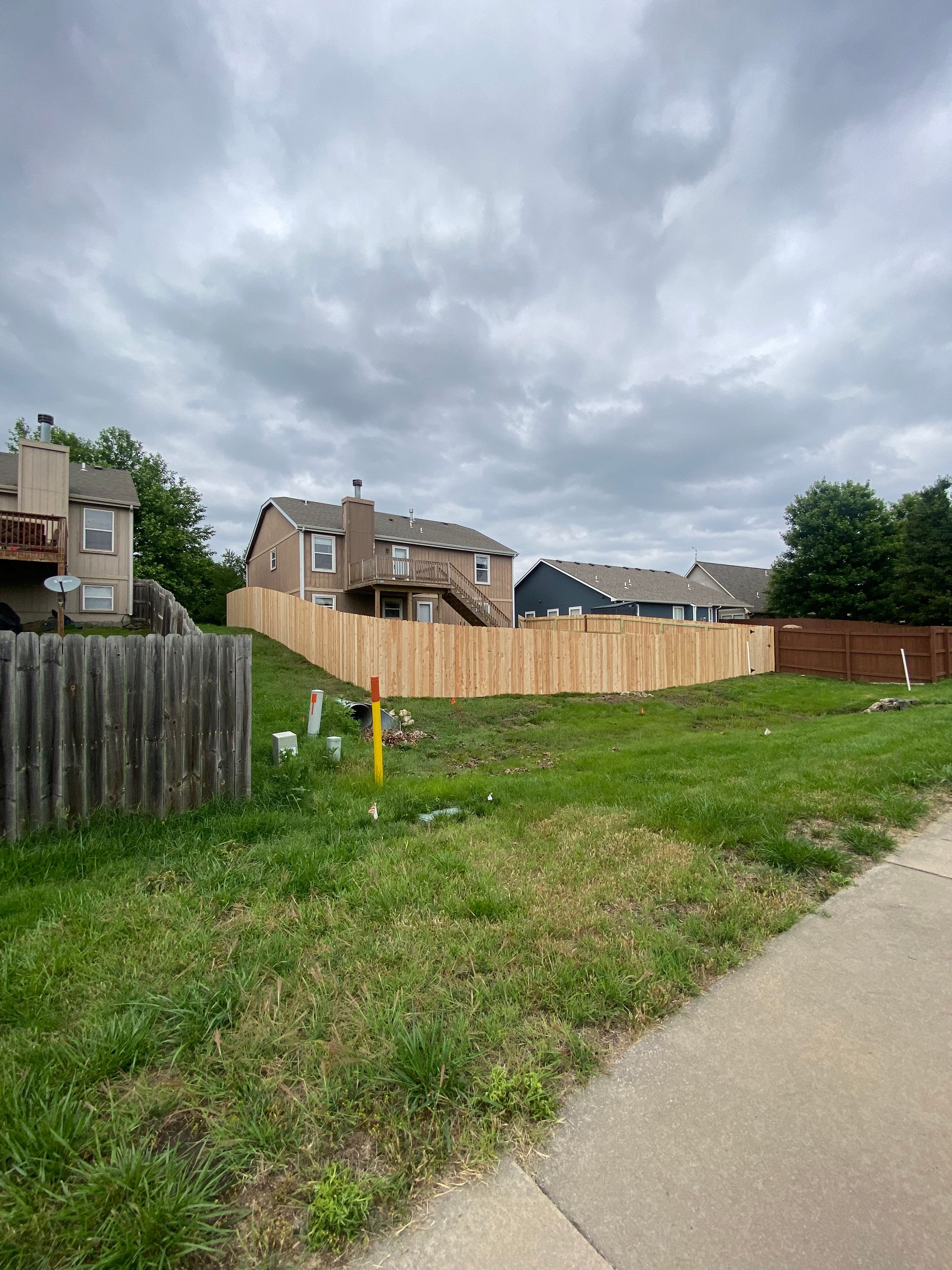 There is a wooden fence in the middle of a grassy field.