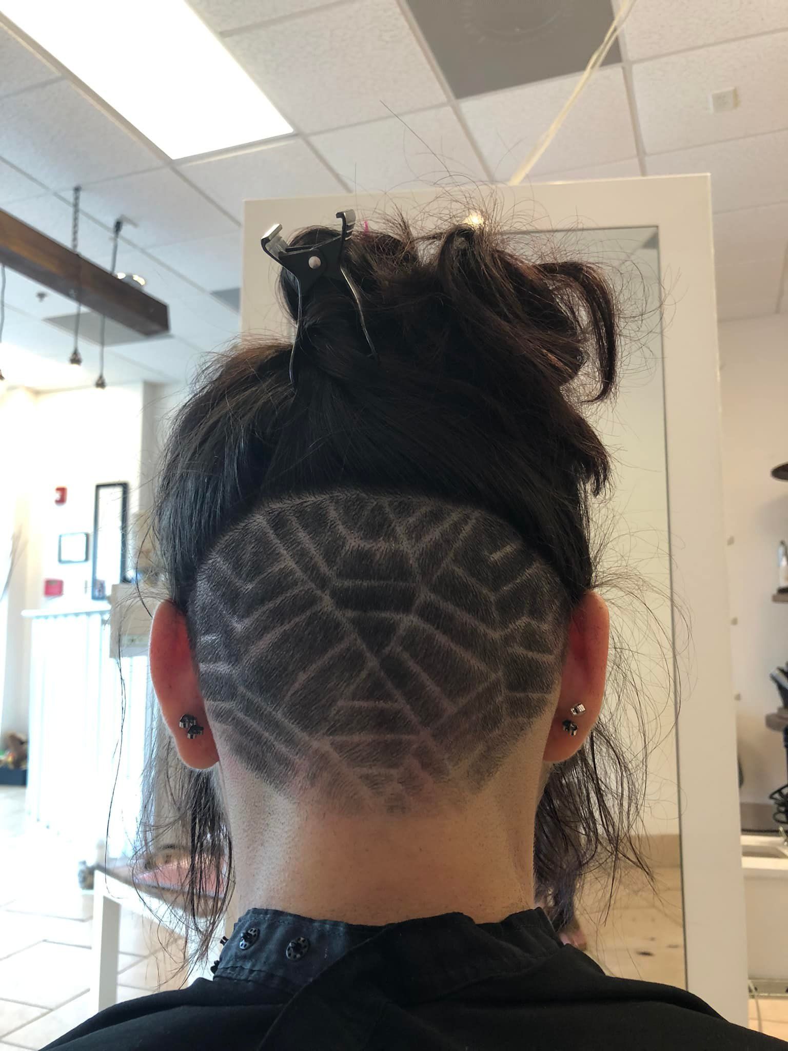 The back of a woman 's head with a spider web design on it