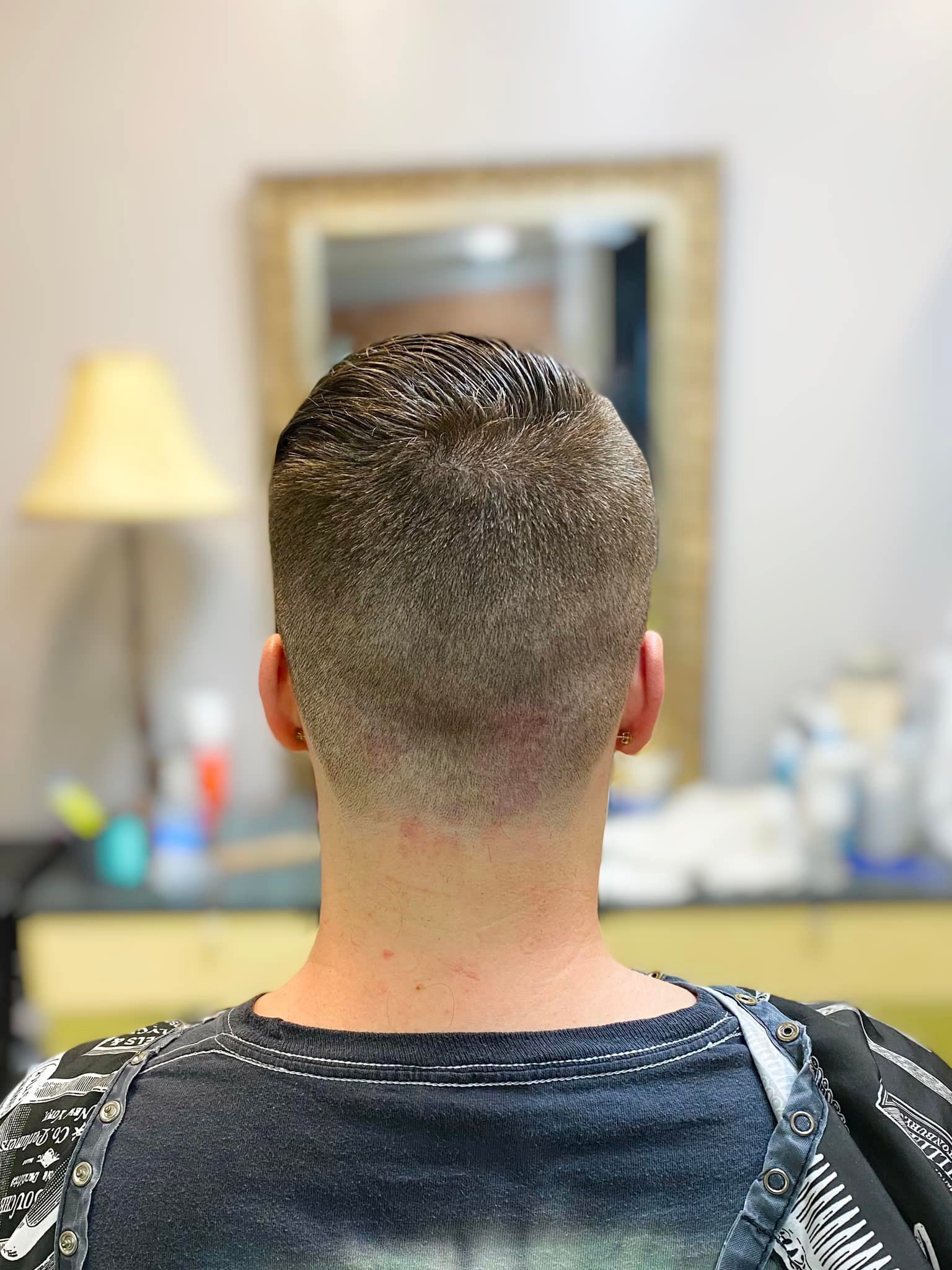 A man is getting his hair cut at a barber shop.