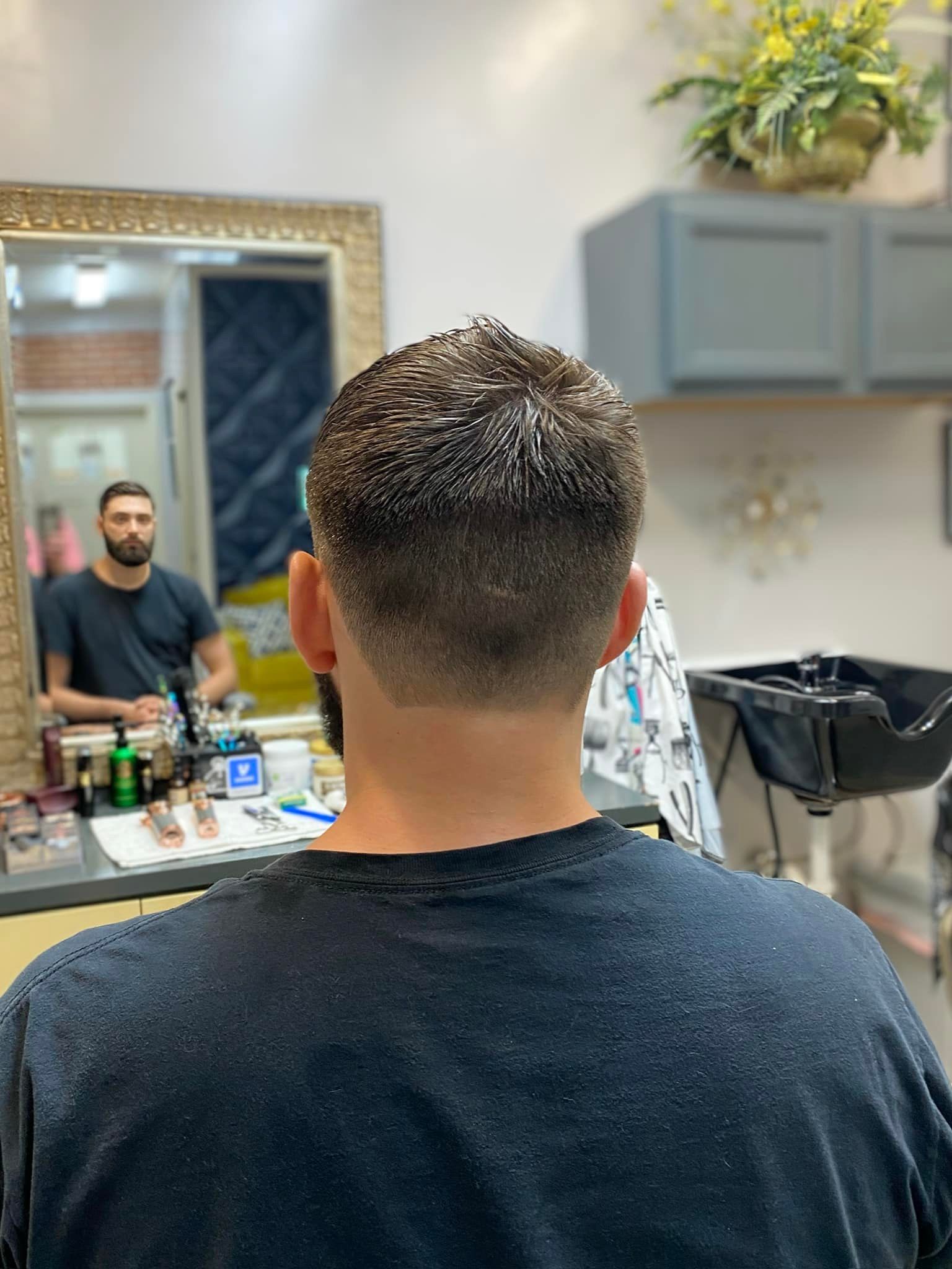 A man is getting his hair cut at a barber shop.