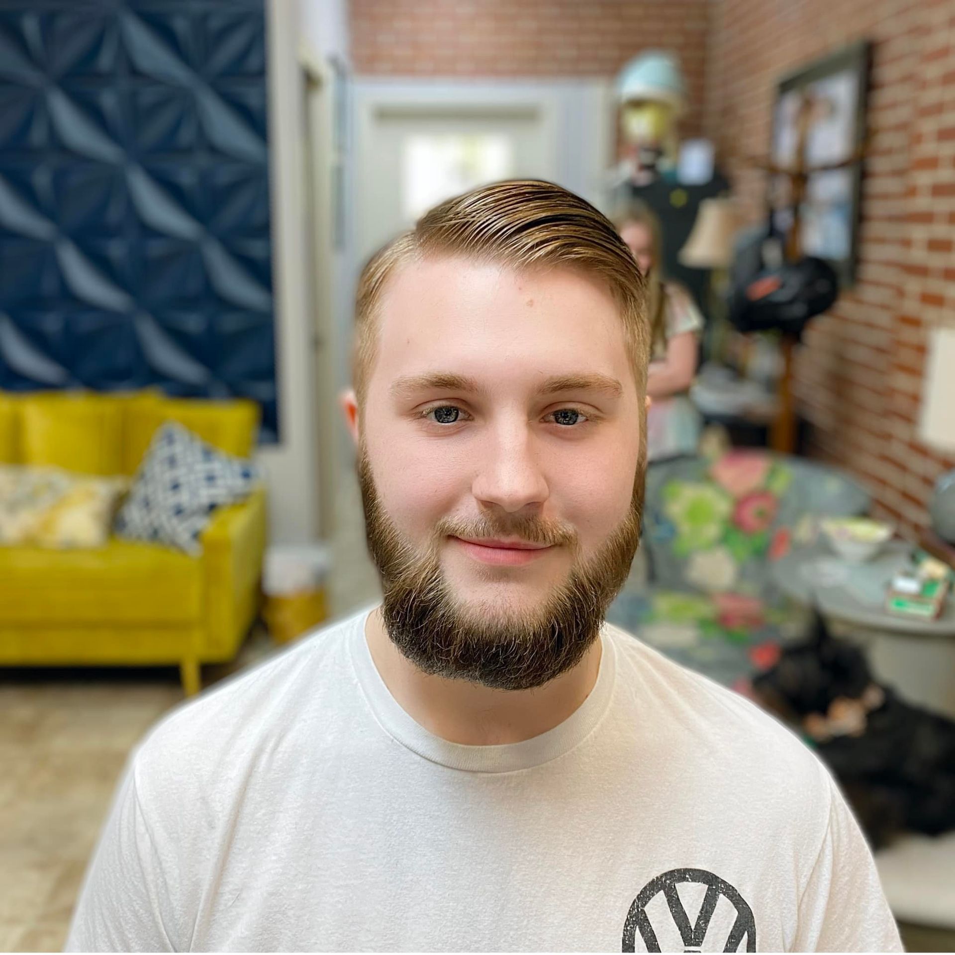 A man with a beard is wearing a white shirt with a vw logo on it