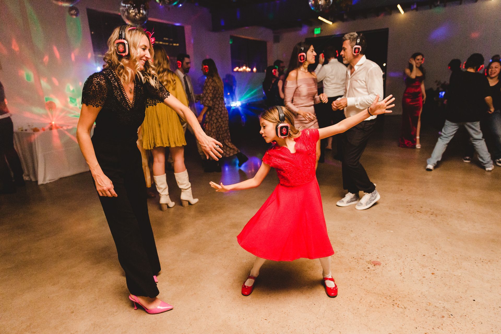 Little Girl Dances with mom at silent disco wedding reception